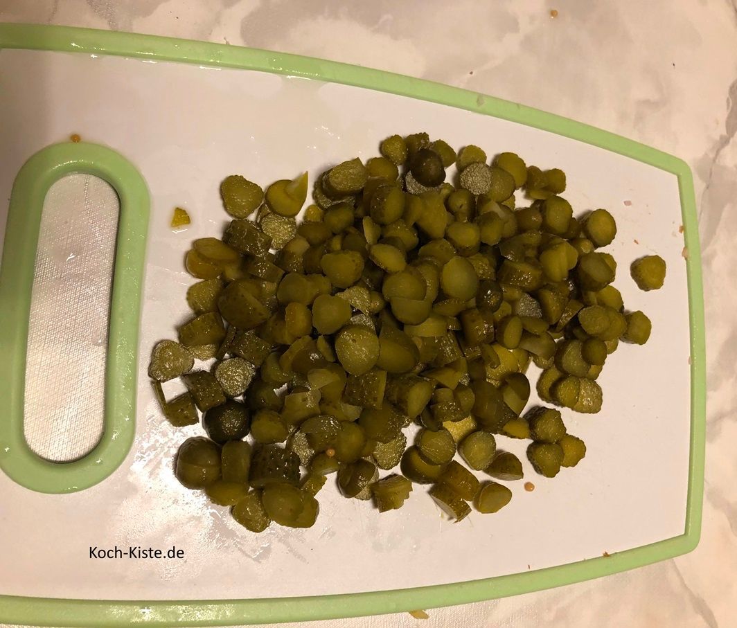 als nächstes entferne von jedem Cornichons oben und unten ein kleines Stück und schneide sie in kleine Stücke