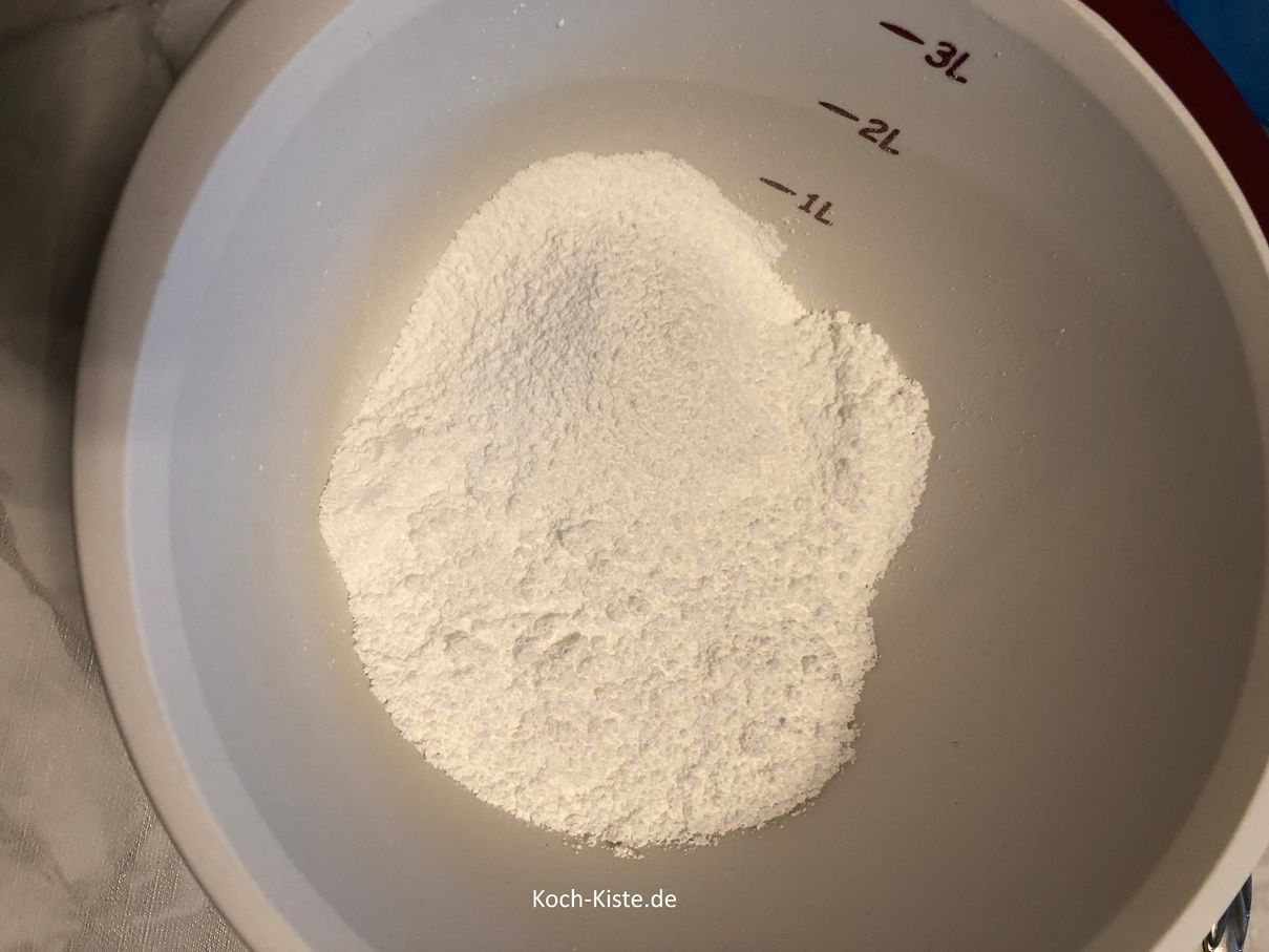 dann nehme eine Rührschüssel und lege ein Passiersieb auf. Dann gebe nach und nach den Puderzucker in das Sieb und streiche mit einem Esslöffel hin und her , so dass der geisiebte Puderzucker in die Rührschüssel fällt.