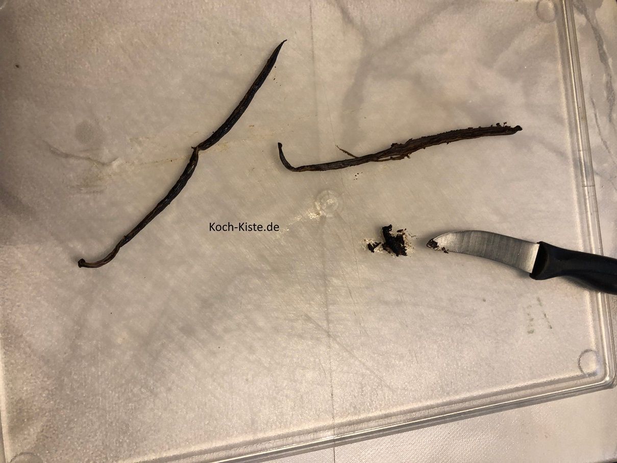 jetzt lege die Vanilleschote auf das Schneidebrett und schneide sie waagerecht auf. Dann kratze aus der Mitter der Vanilleschote das Mark heraus und gebe es mit in die Rührschüssel.