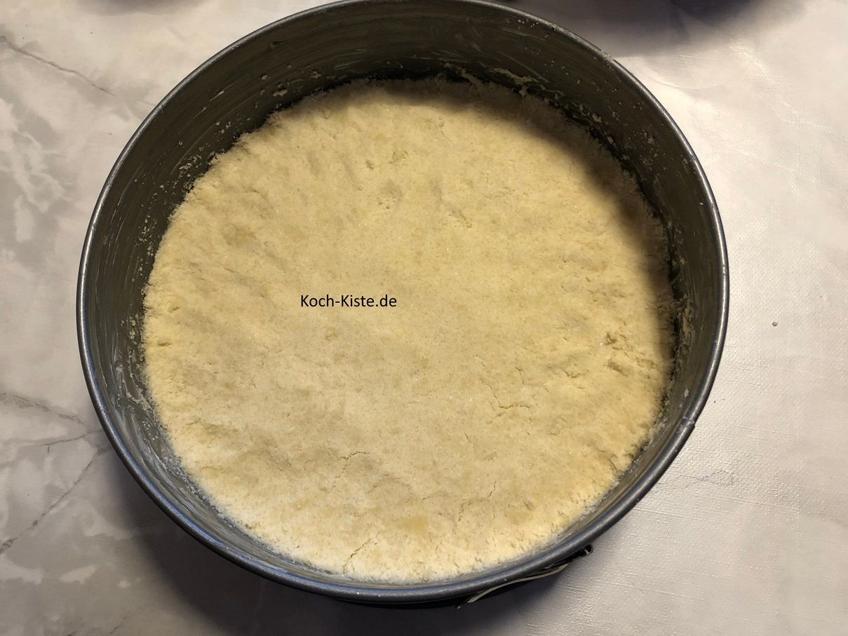 gebe die Teigkrümmel in eine gefettete Springform und drücke mit deinem Handrücken den Teig etwas fest