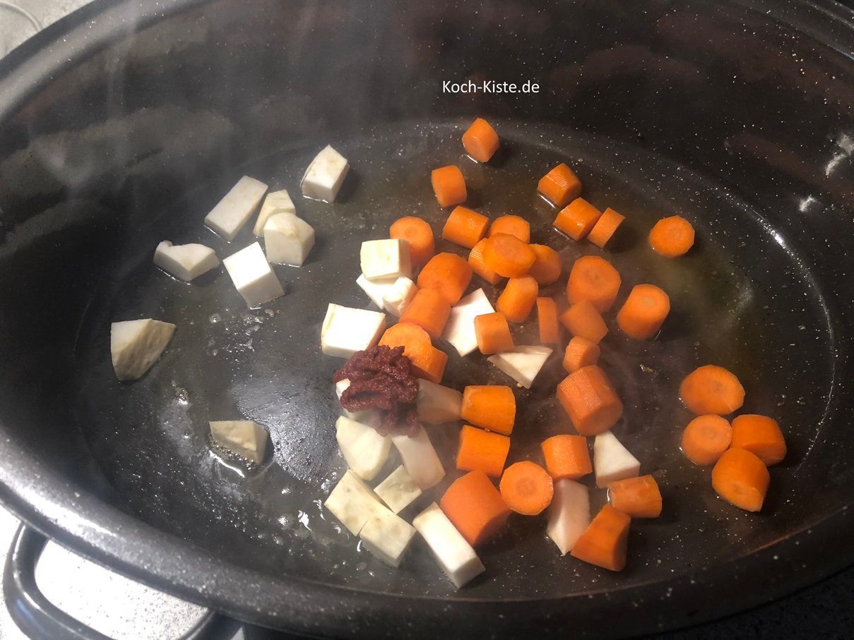 kippe das Gemüse mit in den Bräter und gebe 3 Esslöffel Tomatenmark hinzu.