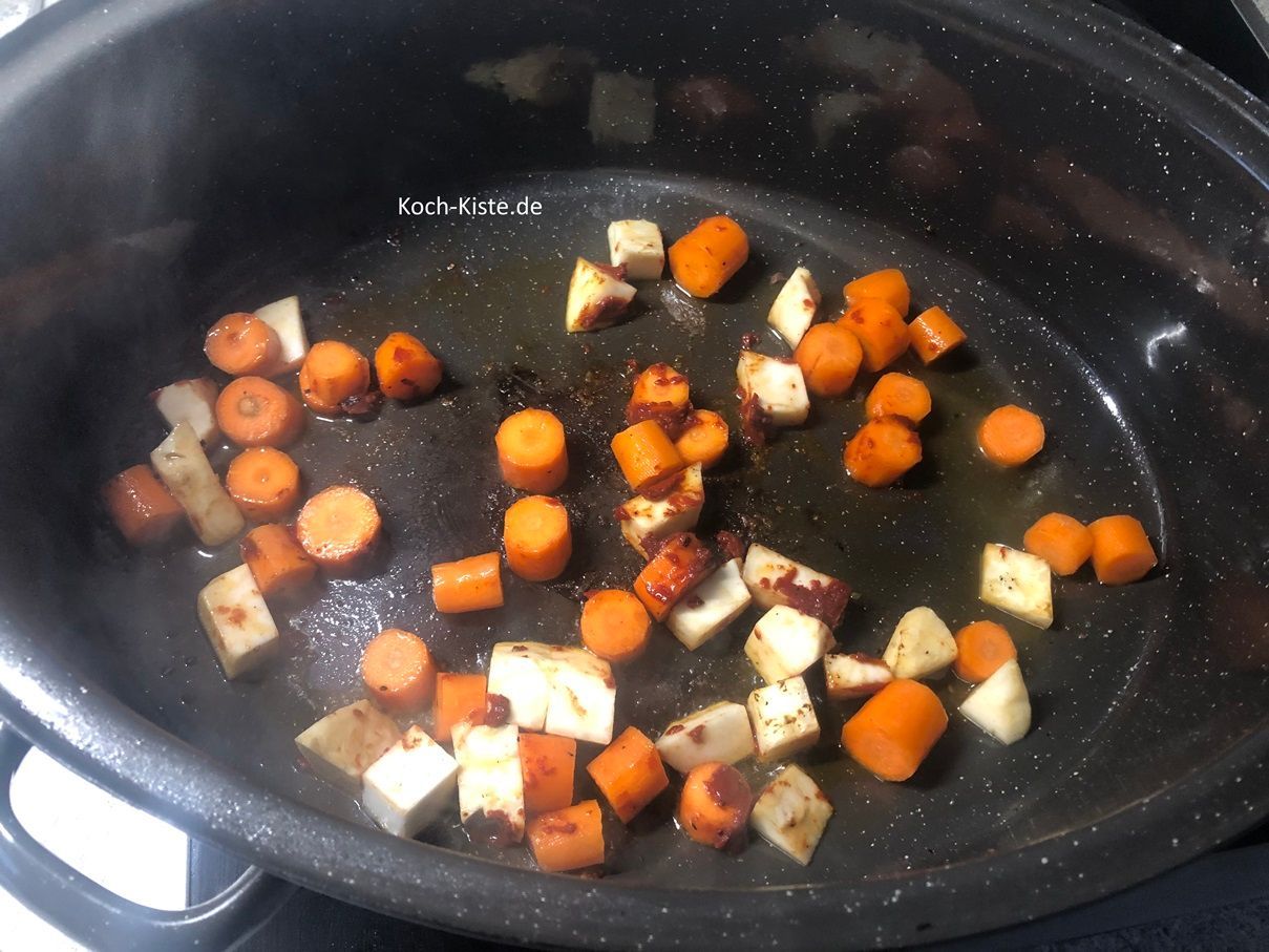 verrühre mit dem Pfannenwender das Tomatenmark gleichmäßig im Gemüse