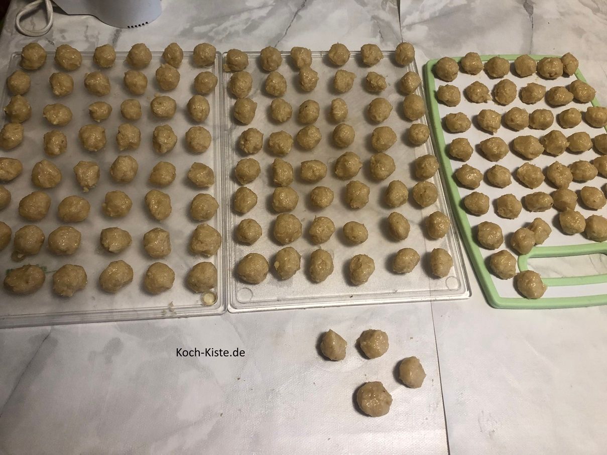 dann ziehe Dir Vinyl-Einmalhandschuhe an, nehme Dir immer etwas Teig und forme daraus kleine Kugeln. Diese legst Du auf die Beiden Backbleche und auf bereit gelegte Schneidebretter