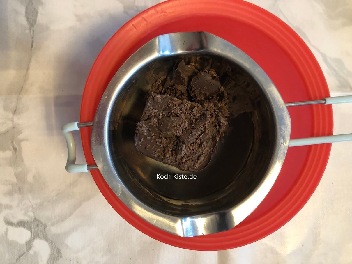 gebe 150 g Schokoladenglasur in die Schmerlzschale und gieße kochendes Wasser in die untere Schüssel