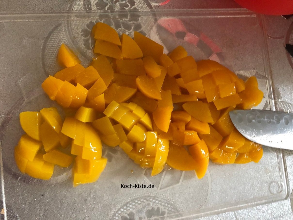 hebe mit der Gabel die Pfirsichhälften nacheinander auf das Schneidebrett und schneide sie in kleine Stücke