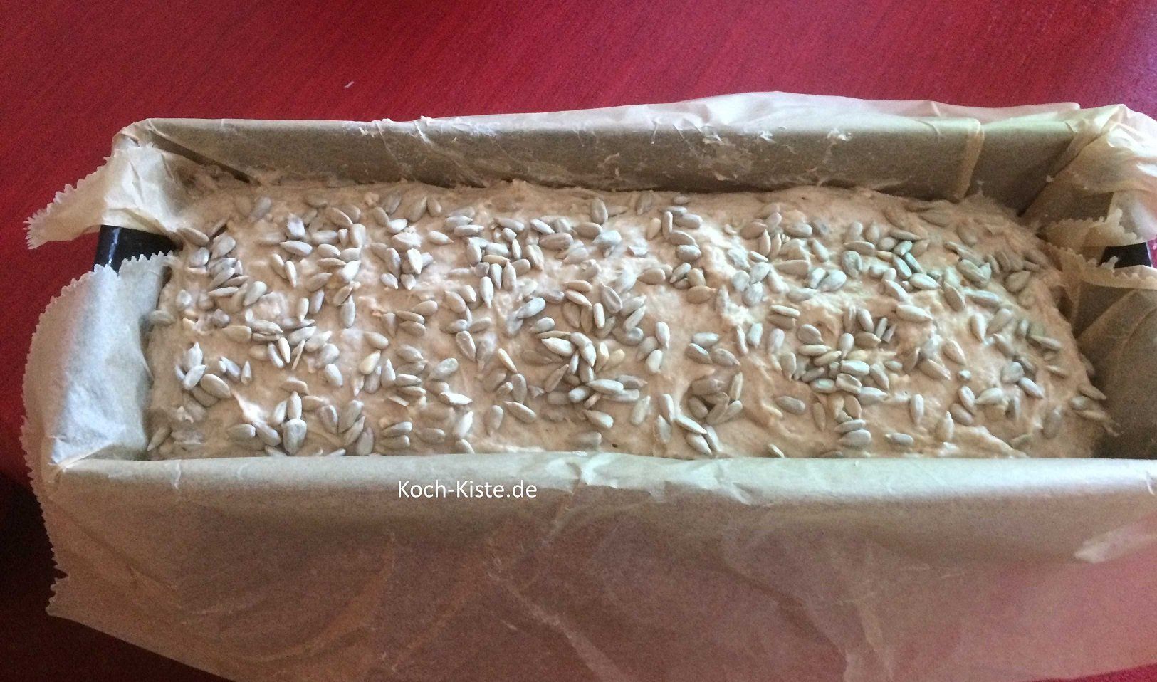 Teig mit einem Teigschaber in die Kastenform