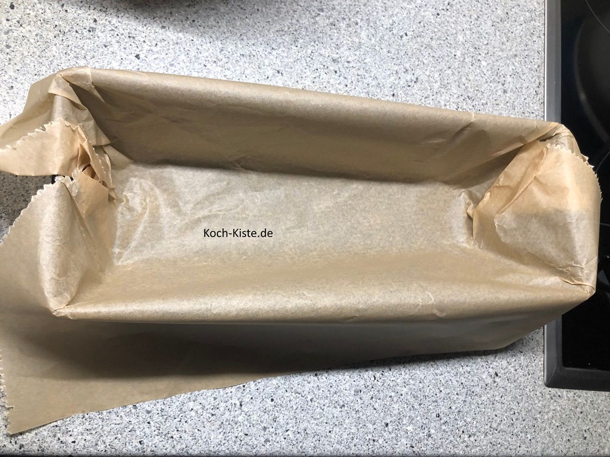 lege die Kastenform mit einen Bogen Backpapier aus