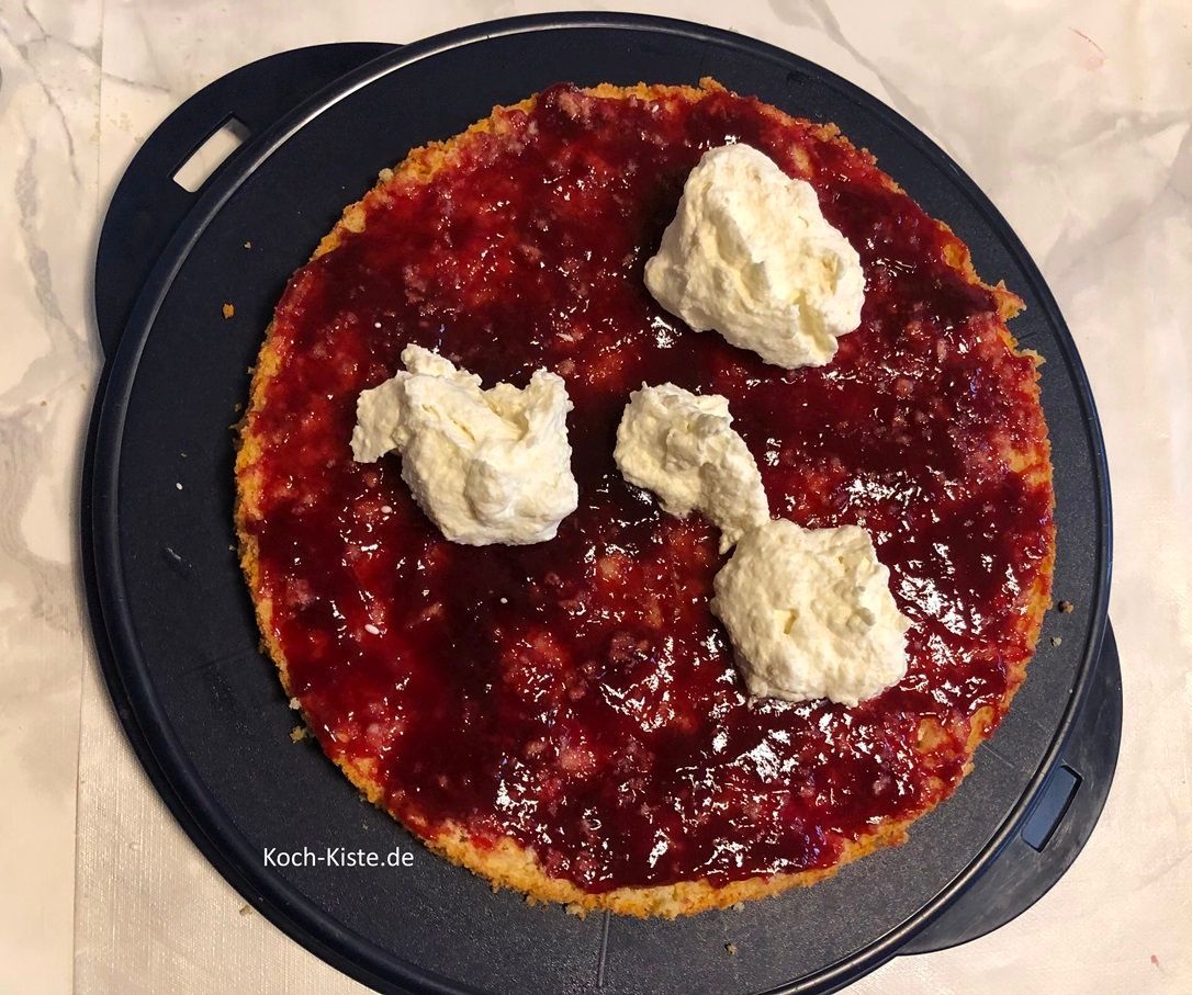 gebe 5 gute Esslöffel der Sahnemasse auf den unteren Tortenbodenteil und verstreiche mit dem Tortenspachtel alles gleichmäßig.