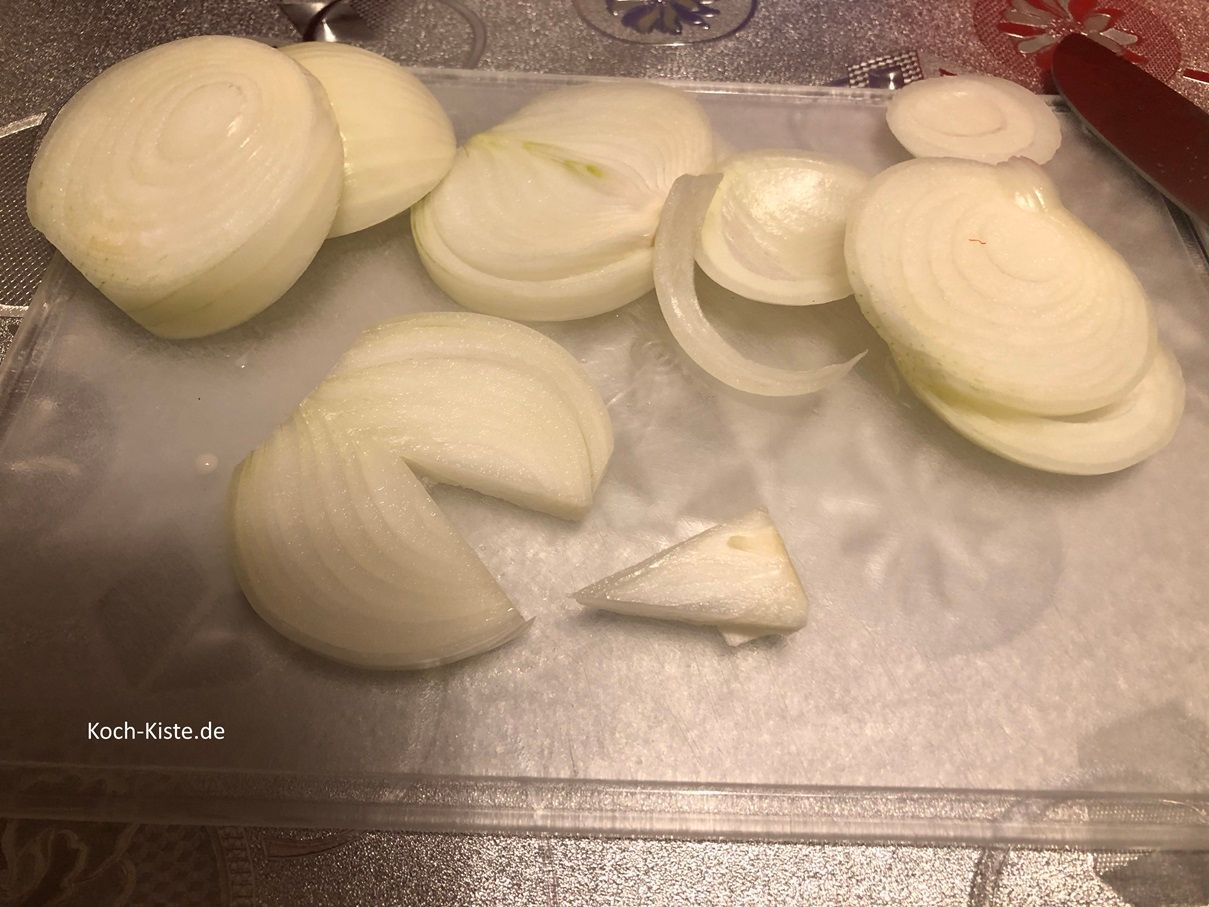 schneide die Gemüsezwiebel in Scheiben. Den eventuell vorhandenen Kern ( trocken, hart) im unteren Teil musst Du heraus schneiden .
