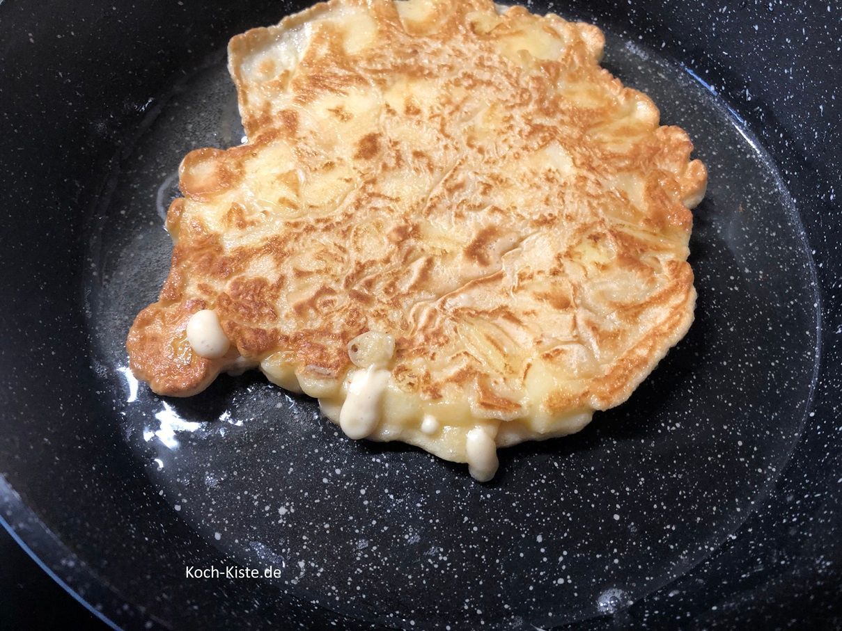 wenn noch flüssiger Teig vorhanden war , wird der Pfannkuchen erneut gewendet, damit der Teig fest (gar) werden kann.