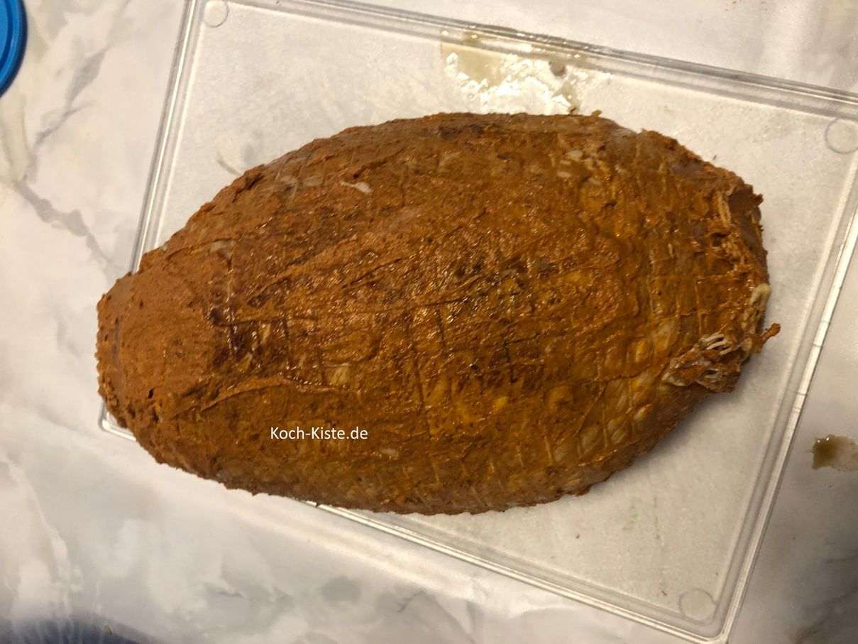 verteile die Würzcreme mit der Teelöffelseite auf der Oberseite des Rollbratens. Dann drehe den Rollbraten auf die Seite und gebe die Würzcreme auch auf die Unterseite und den Rand des Rollbratens