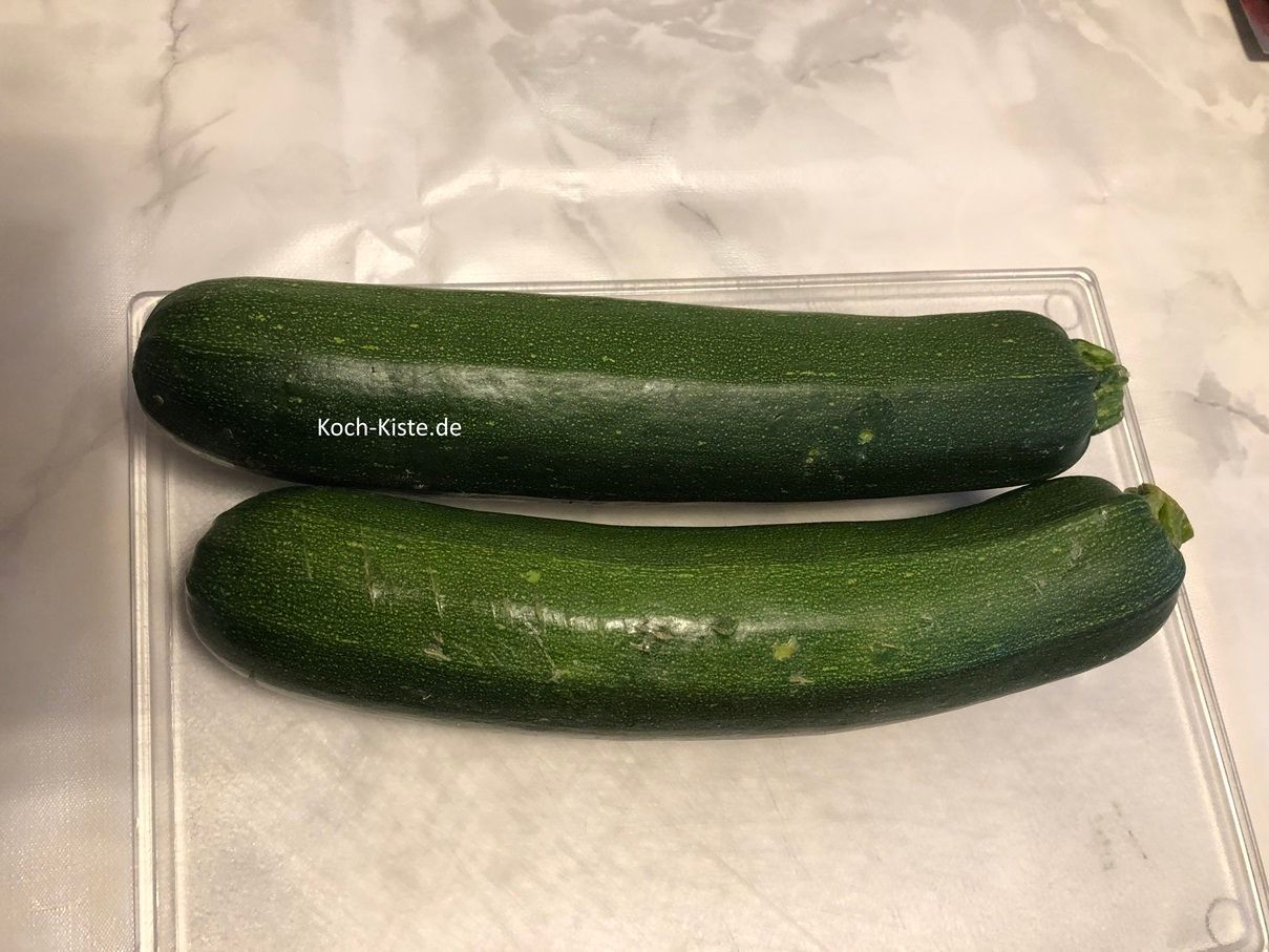 beginne damit die Zucchinis unter kaltem, fließendem Wasser abzuspülen, abzutrocknen und sie auf das Schneidebrett zu legen
