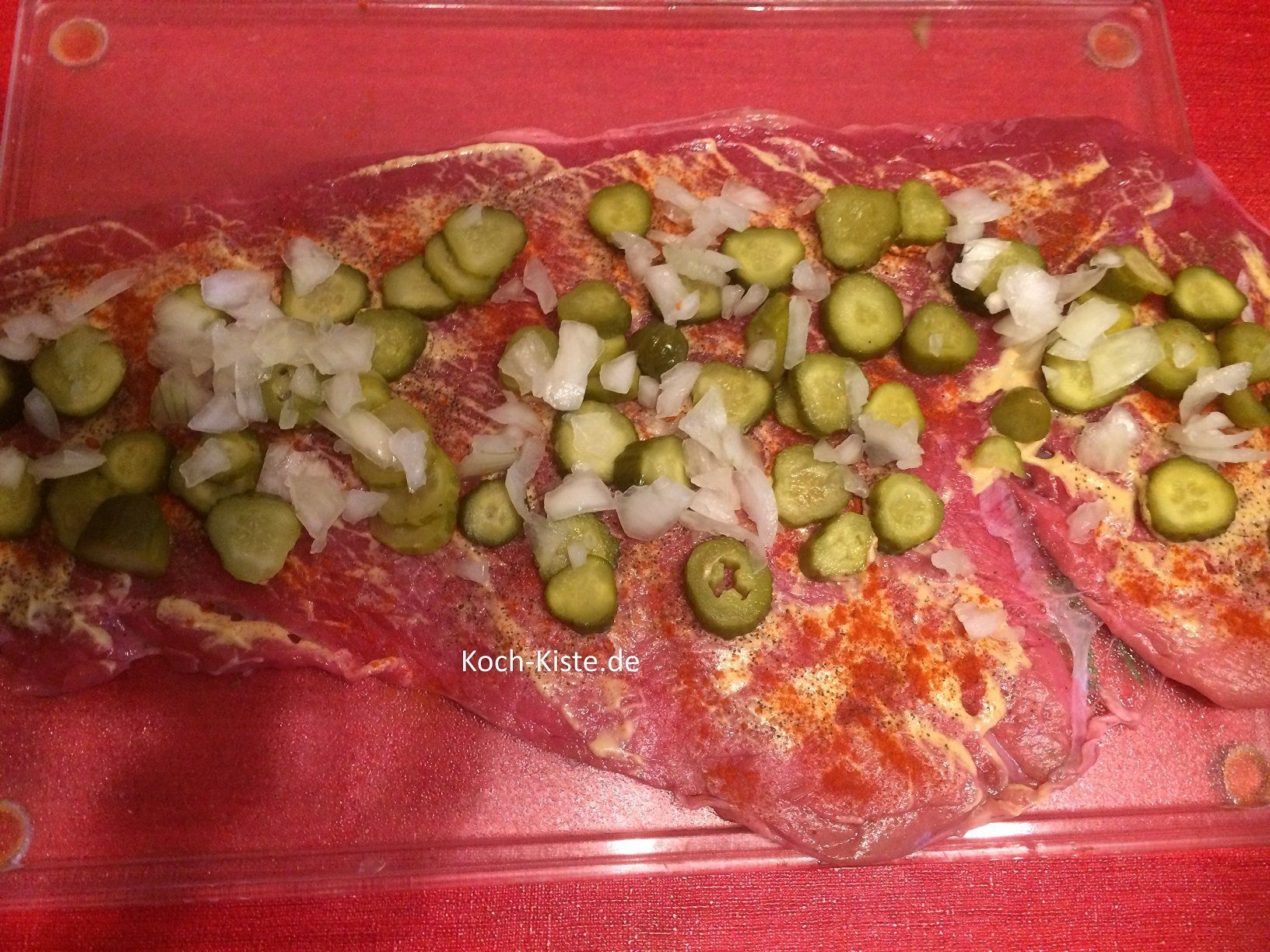 auf der Roulade Zwiebeln und Cornicons verteilen