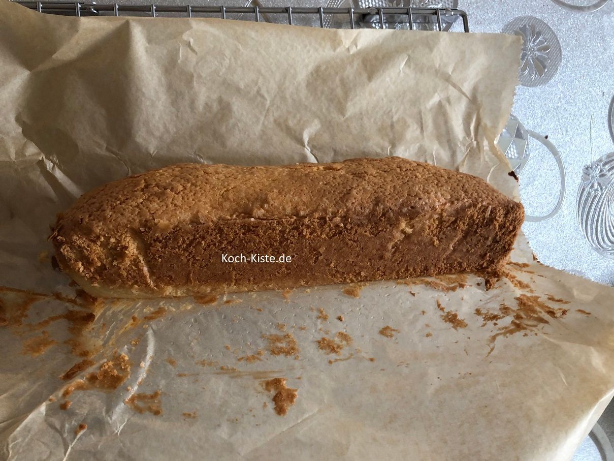 hebe den Sandkuchen am Backpapier aus der Form und lege ihn seitlich auf das Abkühlgitter. Nun kannst Du das Backpapier vorsichtig abziehen.