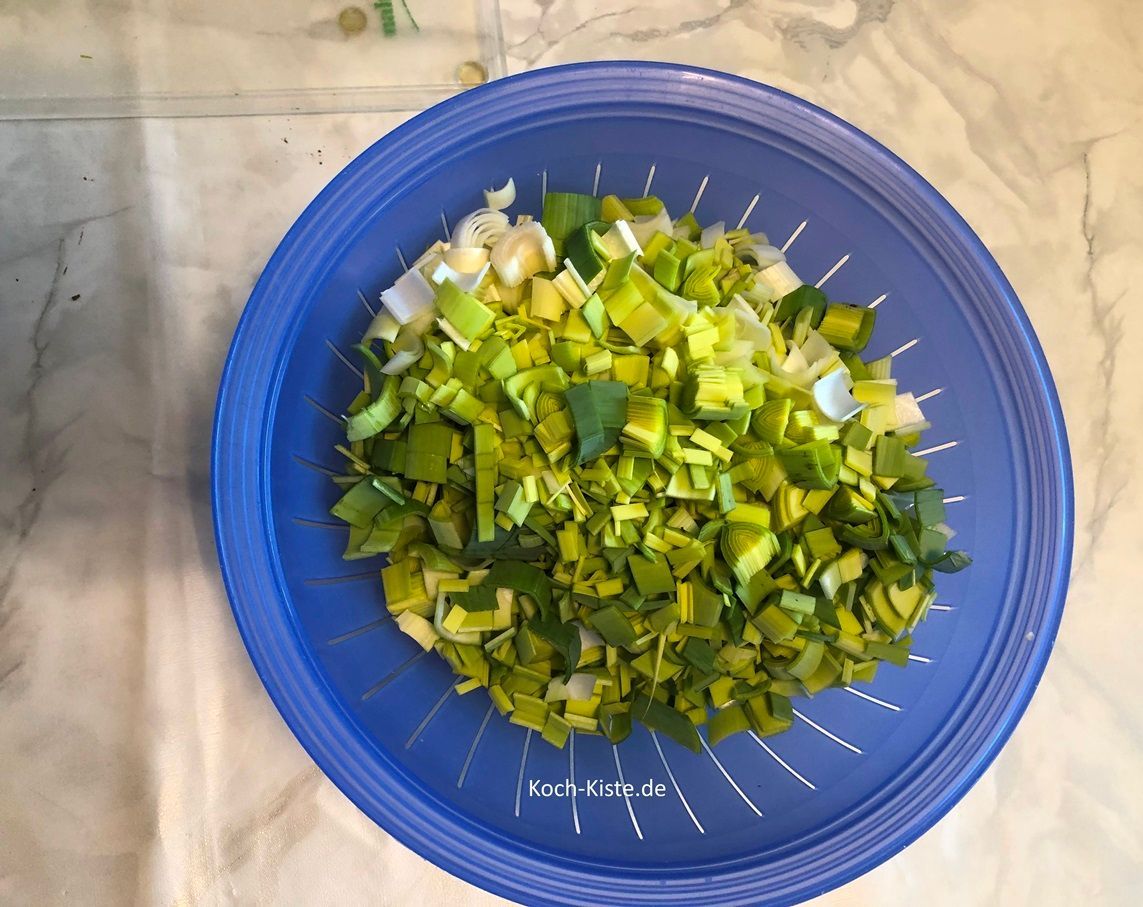 gebe die Porreestücke in ein Küchensieb und spüle sie gründlich unter kaltem, fließendem Wasser ab. Es sollten keine Erdreste mehr vorhanden sein.