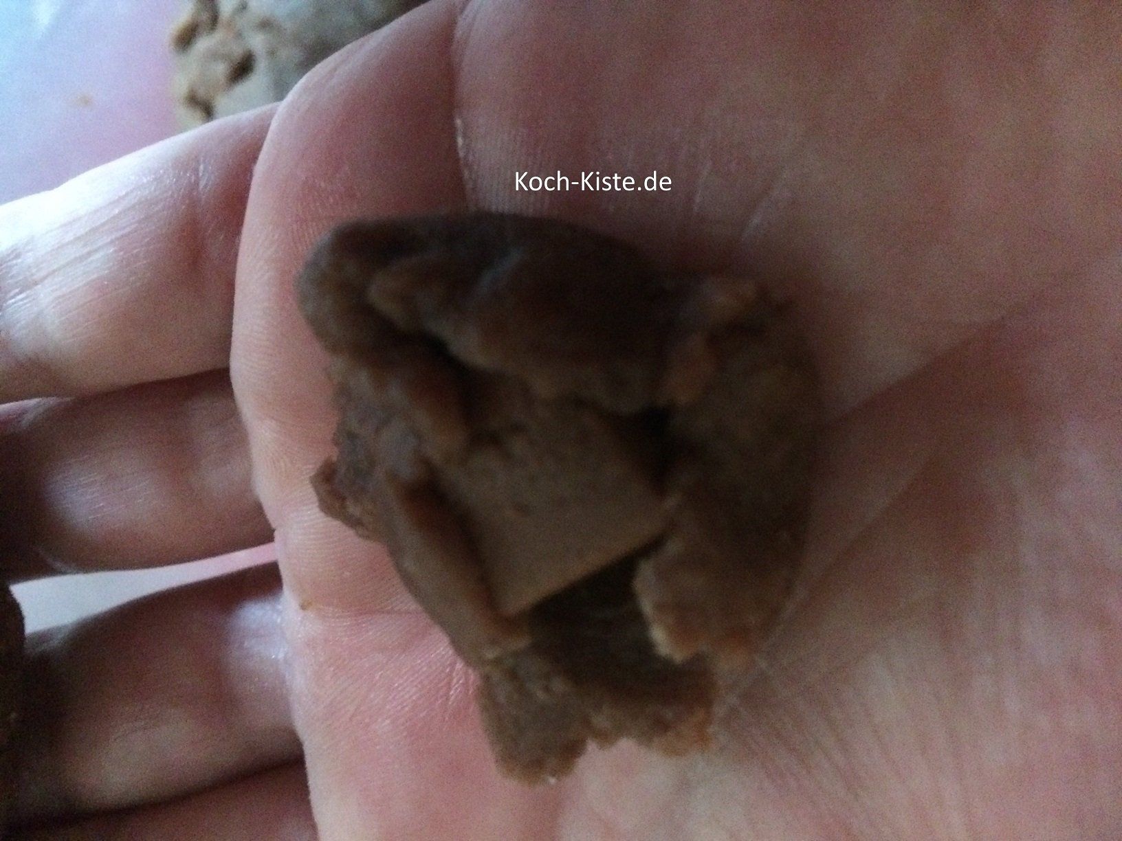 Nougatstück auf den Teig legen und zur Kugel formen