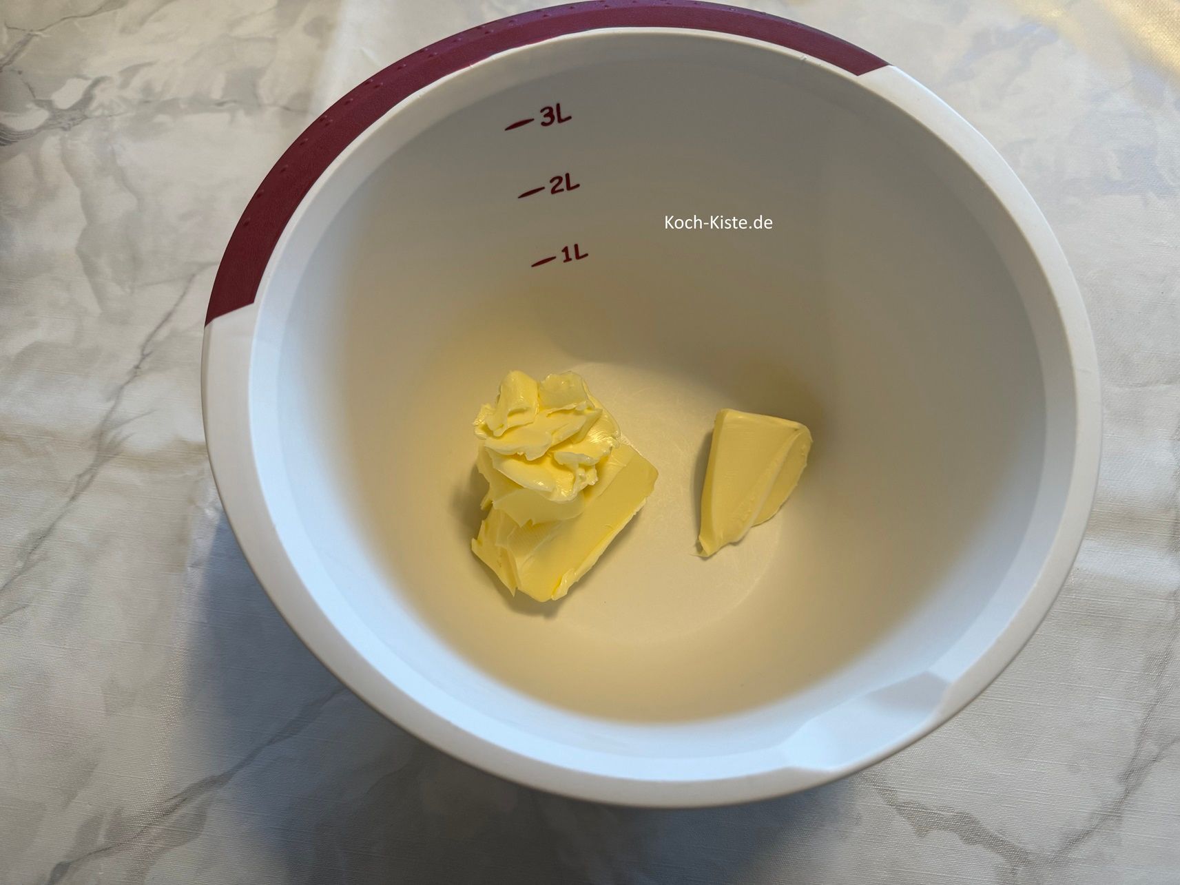 beginne damit die Rührschüssel auf die Küchenwaage zu stellen , auf 0 und mit einem Messer 150 g weiche Butter hinein zu schubsen.