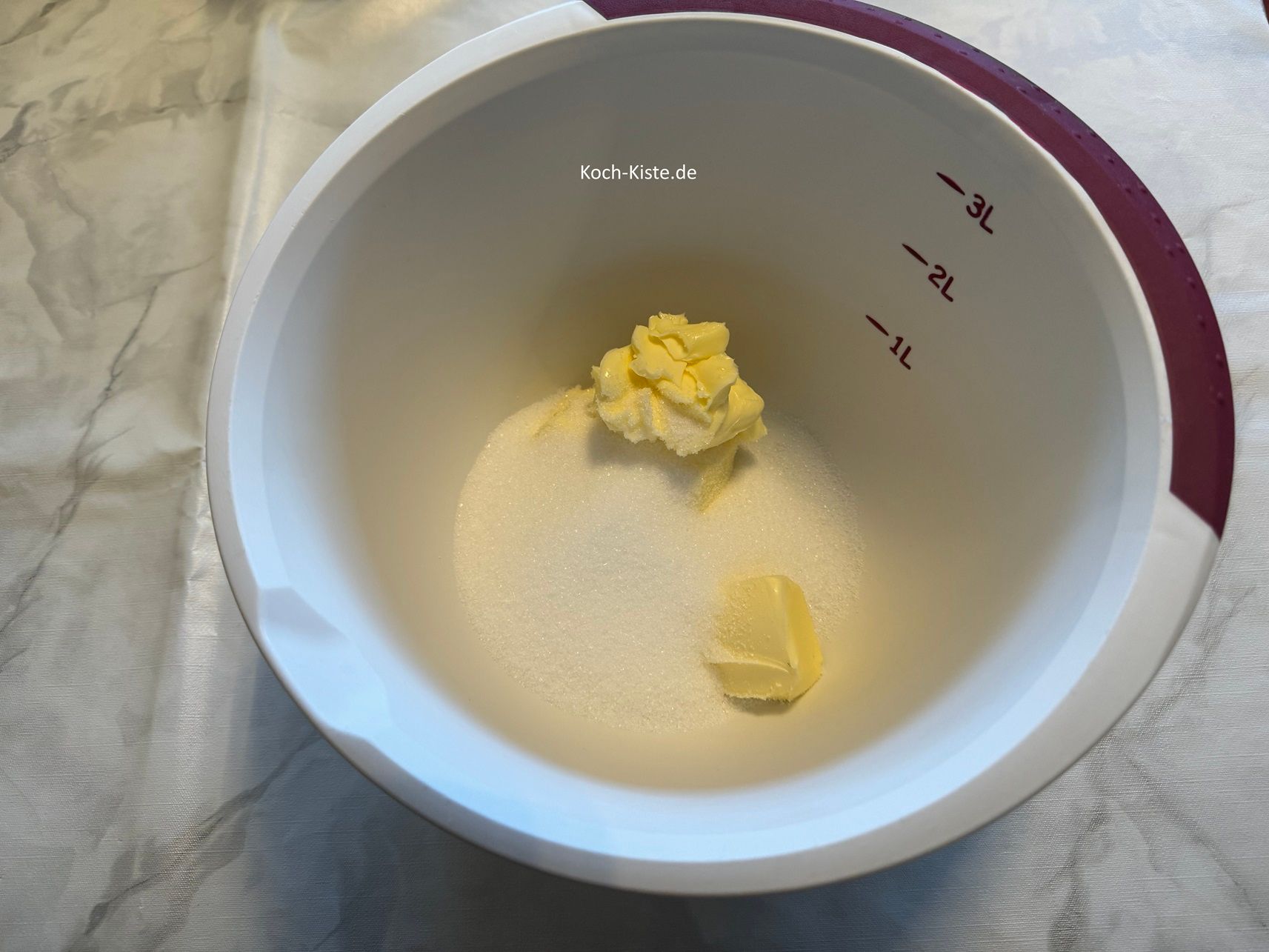 stelle die Rührschüssel wieder auf die Küchenwaage auf 0 und wiege 200 g Zucker ab.