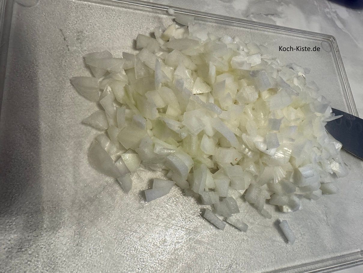 zum Schluss schneide die Zwiebel in Streifen und dann in kleine Stücke. Gebe die Zwiebelstücke in eine Schüssel .