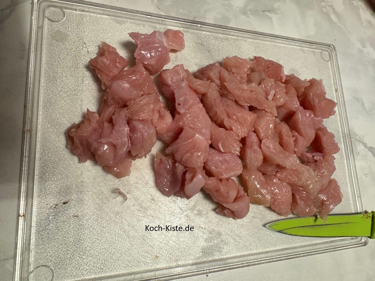 lege das abgespülte und trocken getupfte Putenbrustfilet auf das Schneidebrett und schneide es in mundgerechte Stücke