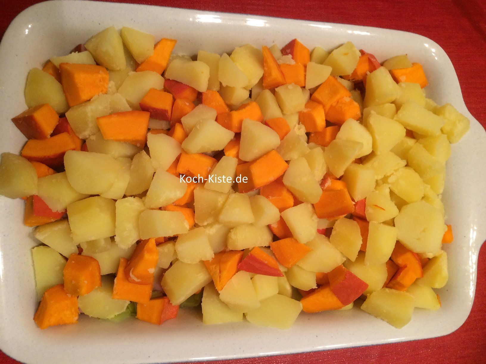 Kartoffel-Kürbis Mischung mit auf den Auflauf geben
