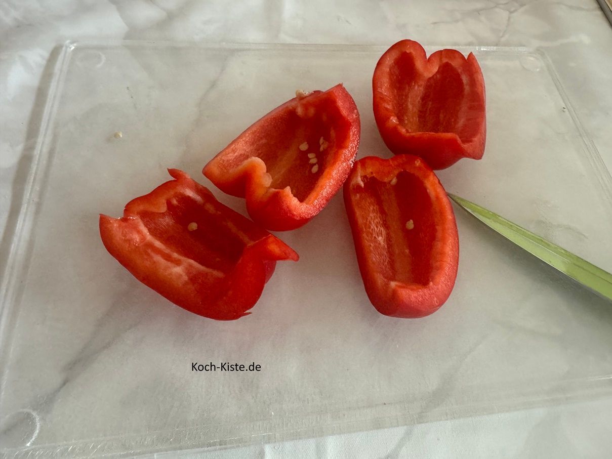Viertel die Paprikahälften und schneide die Innenhäute heraus.