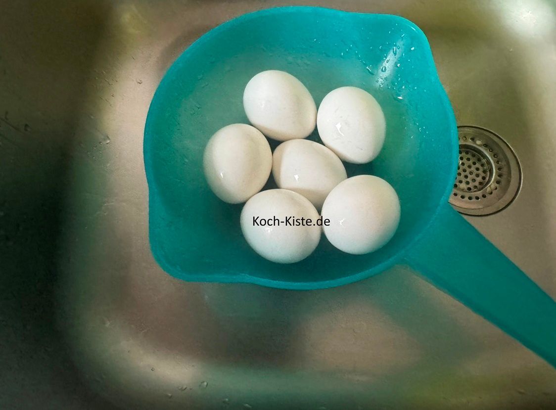 kippe die Eier in ein Küchensieb und schrecke sie gut mit kaltem Wasser ab
