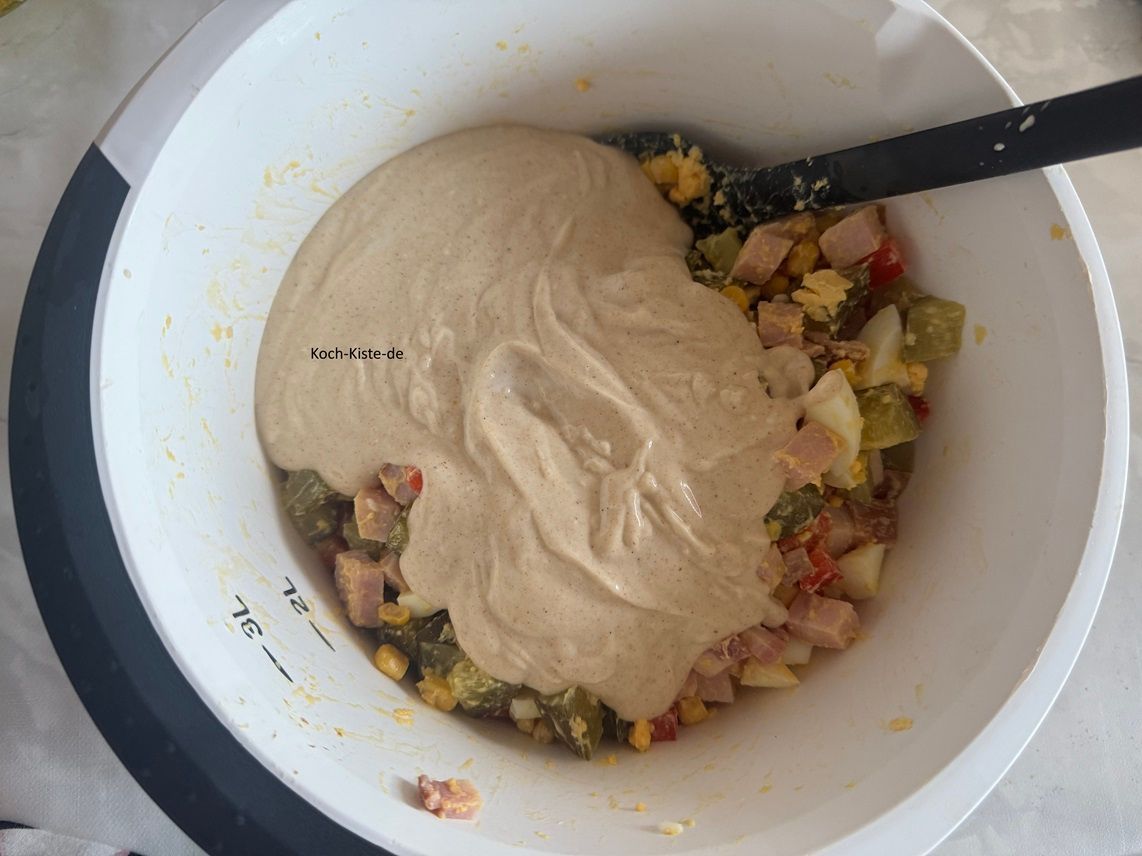 gebe mit einem Teigschaber die Mayomischung zum Salat