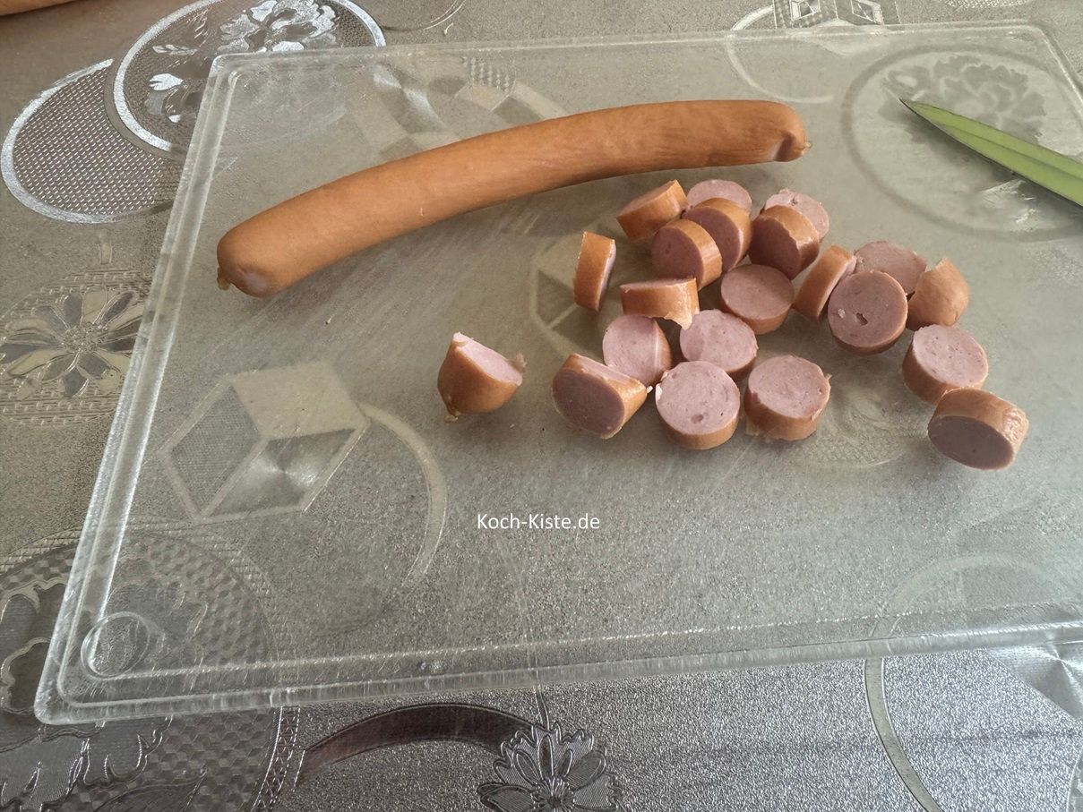 lege die Würstchen auf das Schneidebrett und schneide sie in Scheiben