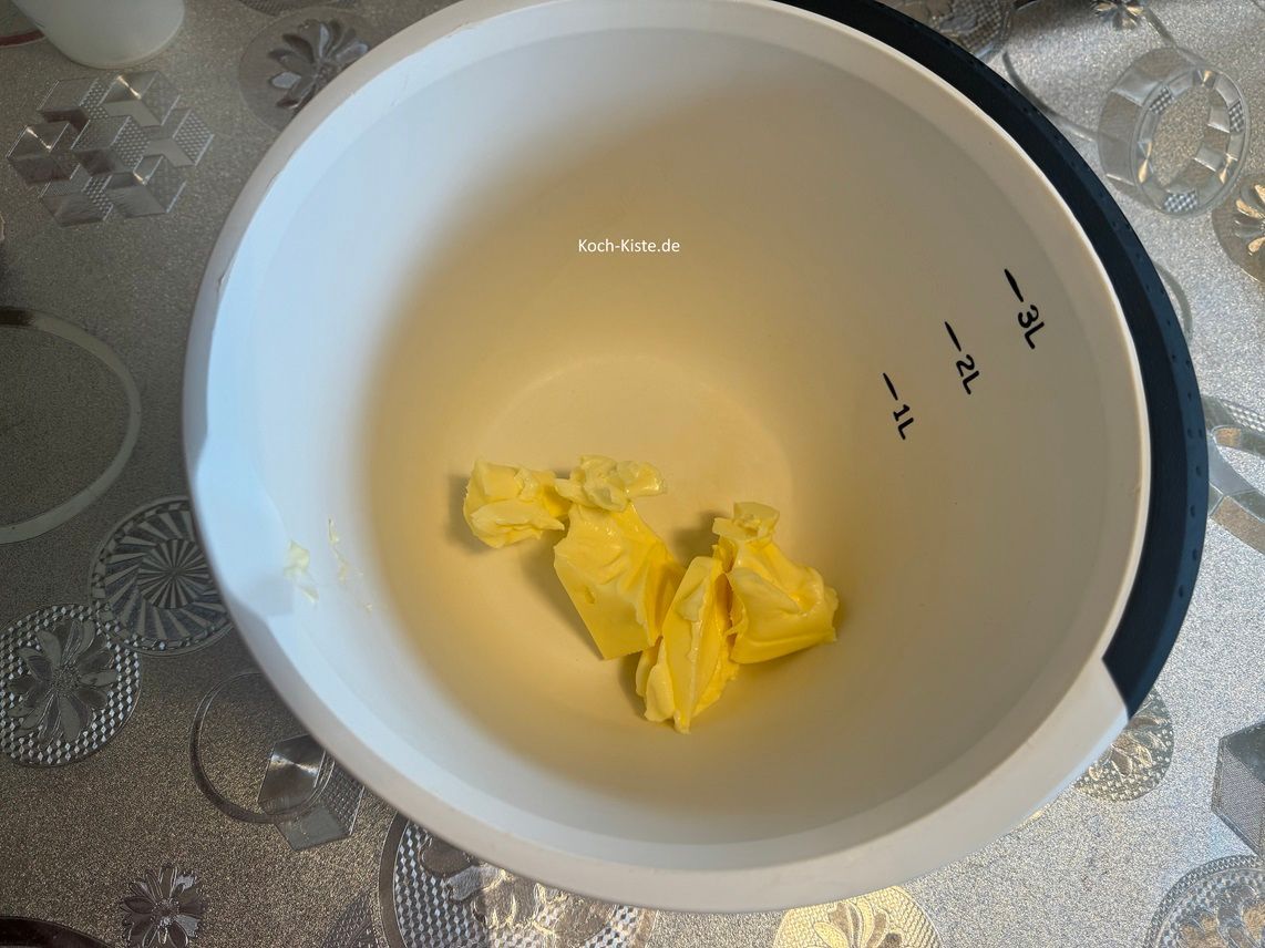 dann stelle die Rührschüssel auf die Küchenwaage auf 0 und schubse mit dem Messer 100 g weiche Butter hinein