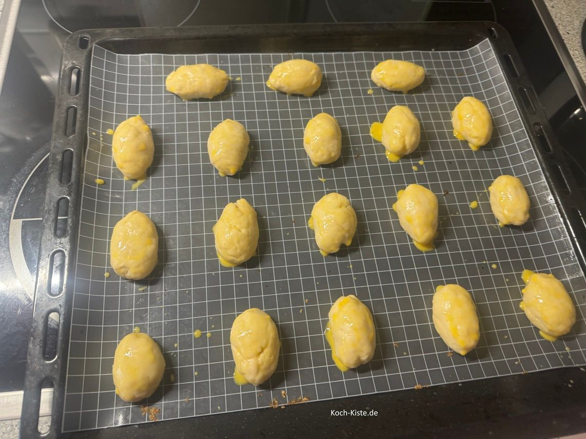 bestreiche auch die kleinen Hefeteigeier mit einem Eigelb-Milch Gemisch