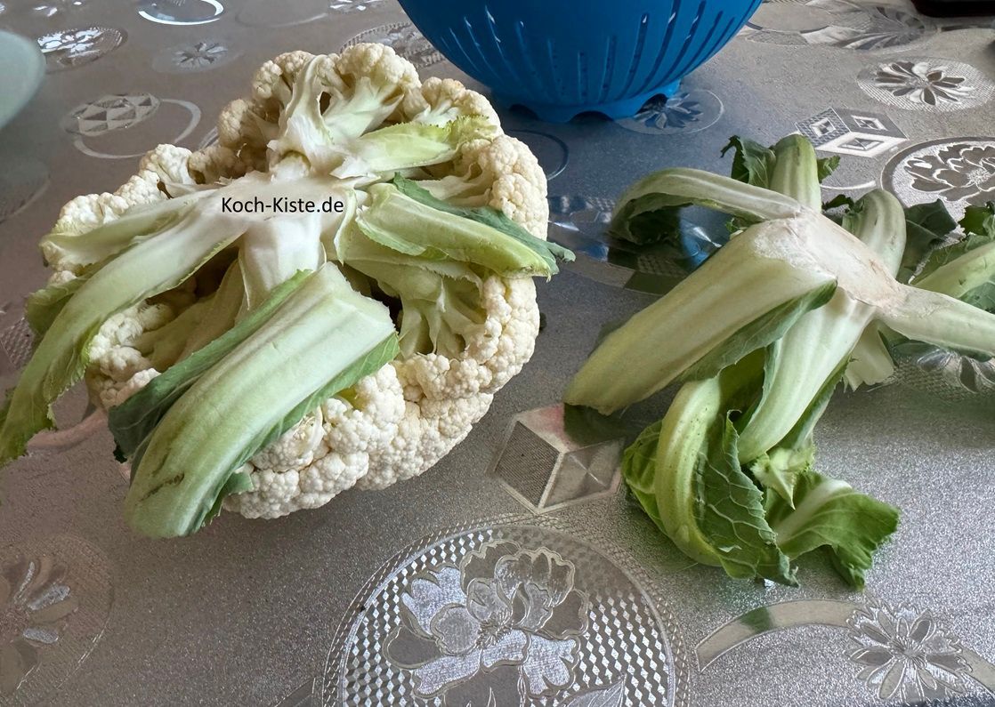 beginne damit den Blumenkohl mit dem Kopf auf den Tisch zu legen und den Strunk unten heraus zu schneiden