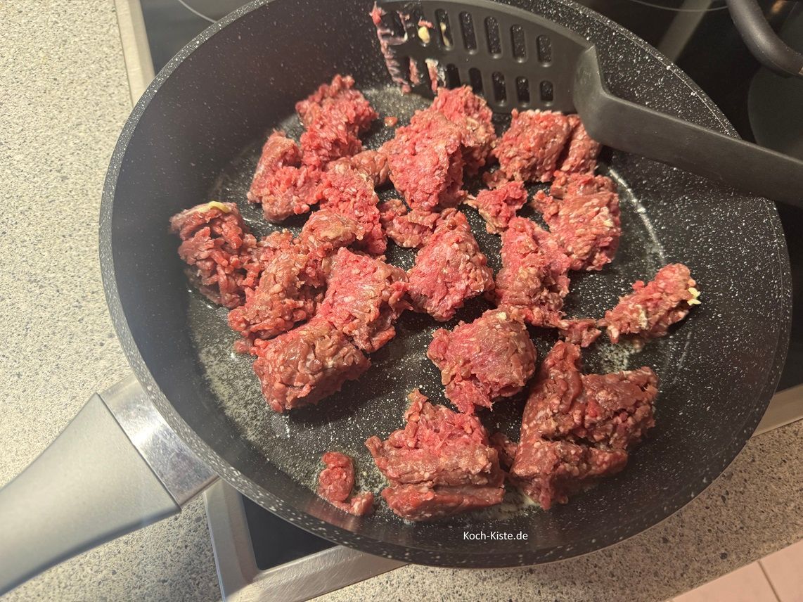 jetzt gebe das Hackfleisch mit in die Pfanne und teile es mit dem Pfannenwender schon in einige Stücke