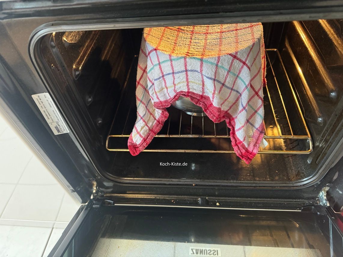 nehme Dir das frische Geschirrhandtuch , halte es unter fast heißes Wasser und wirnge es nur so weit aus, dass es nicht tropft. Dann lege das Handtuch über die Knetschüssel und stelle die Schüssel in den Backofen. Hier muss der Teig bei 50 Grad Ober/ Unterhitze für 30 Mintuen gehen.