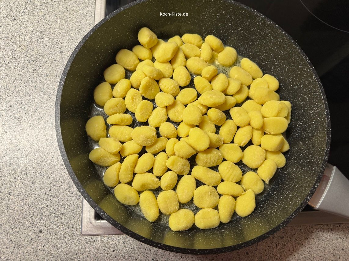 gebe 600 g frische Gnocchi in die Pfanne und lasse sie 6 Minuten anbraten , dabei immer wieder mit dem Pfannenwender wenden