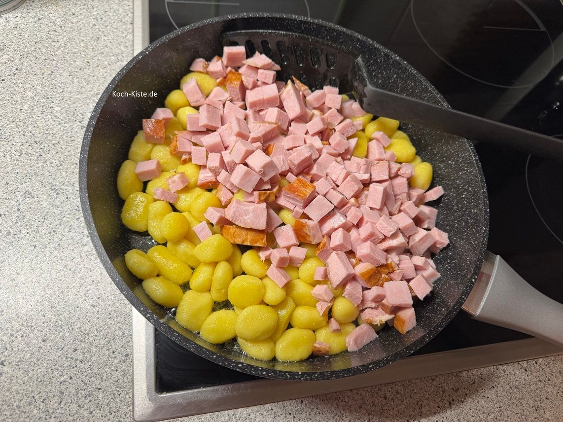 schütte die Kasslerstücke mit in die Pfanne und lasse sie 4 Minuten mit Braten - dabei immer wieder mit dem Pfannenwender wenden