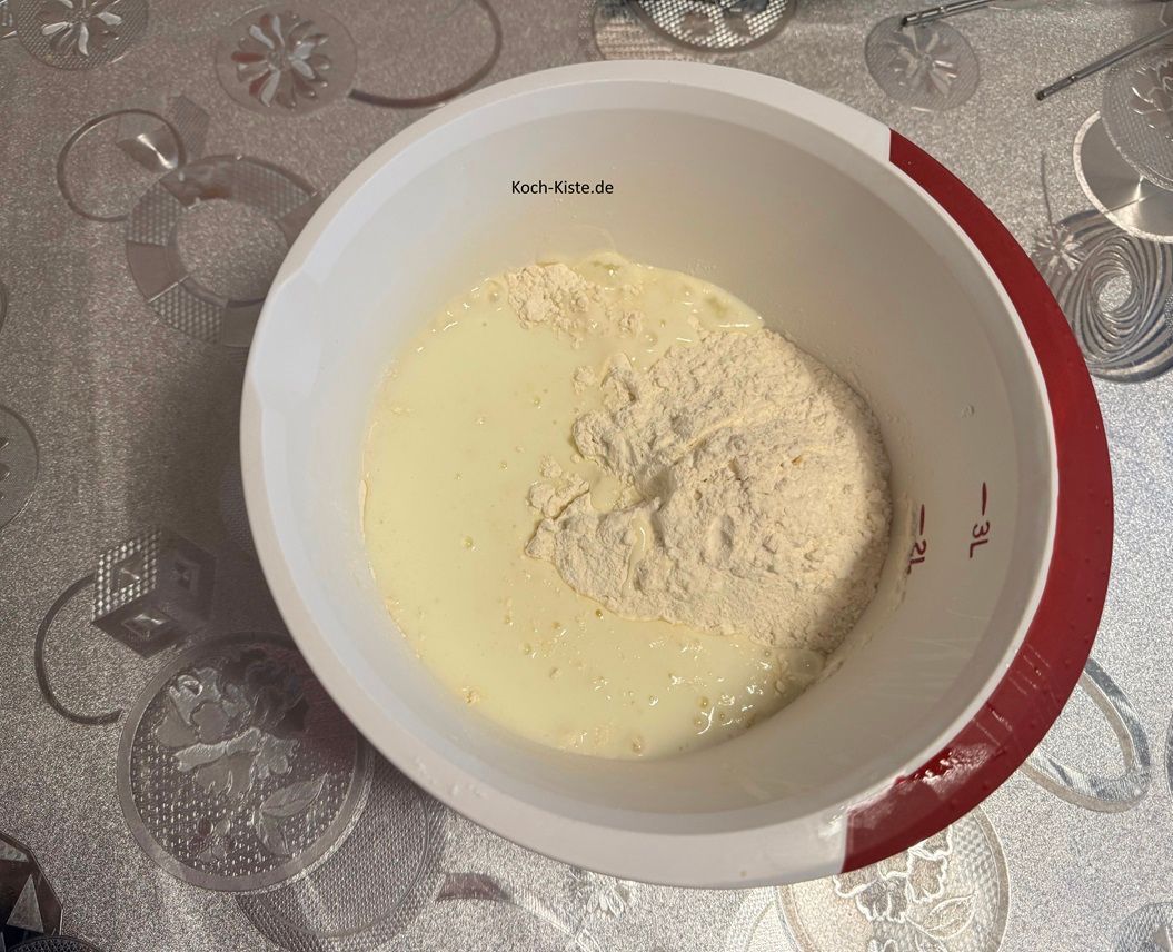 stelle die Rührschüssel wieder auf die Küchenwaage auf 0 und wiege 400 g Dinkelmehl ab.Danach gieße die Buttermilch mit in die Rührschüssel