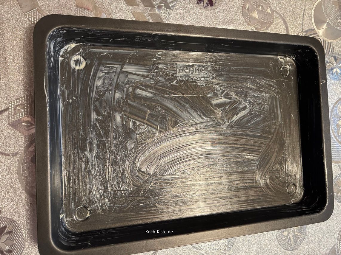 nehme das Butterbrotpapier , damit ein bisschen weiche Butter auf und fette das Backblech.