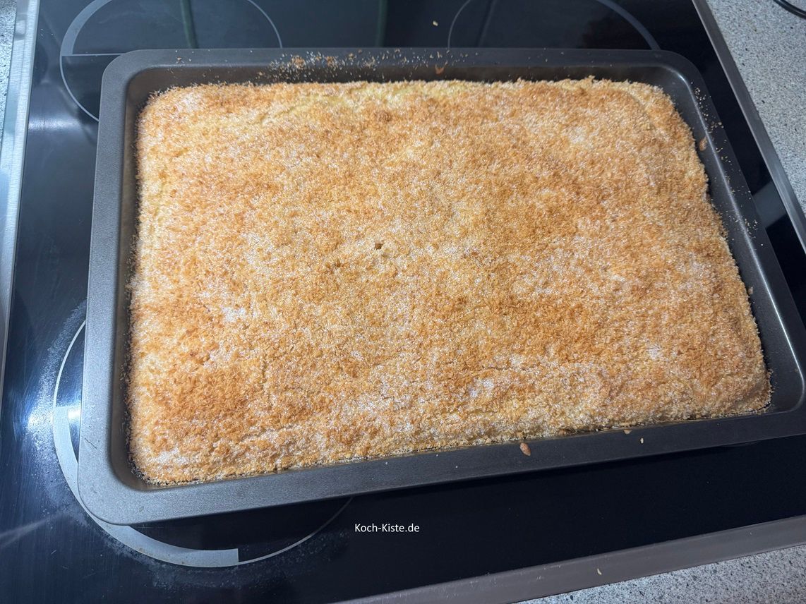 verteile mit dem Esslöffel die flüssige Butter gleichmößig über den Kokos-Kirsch Kuchen