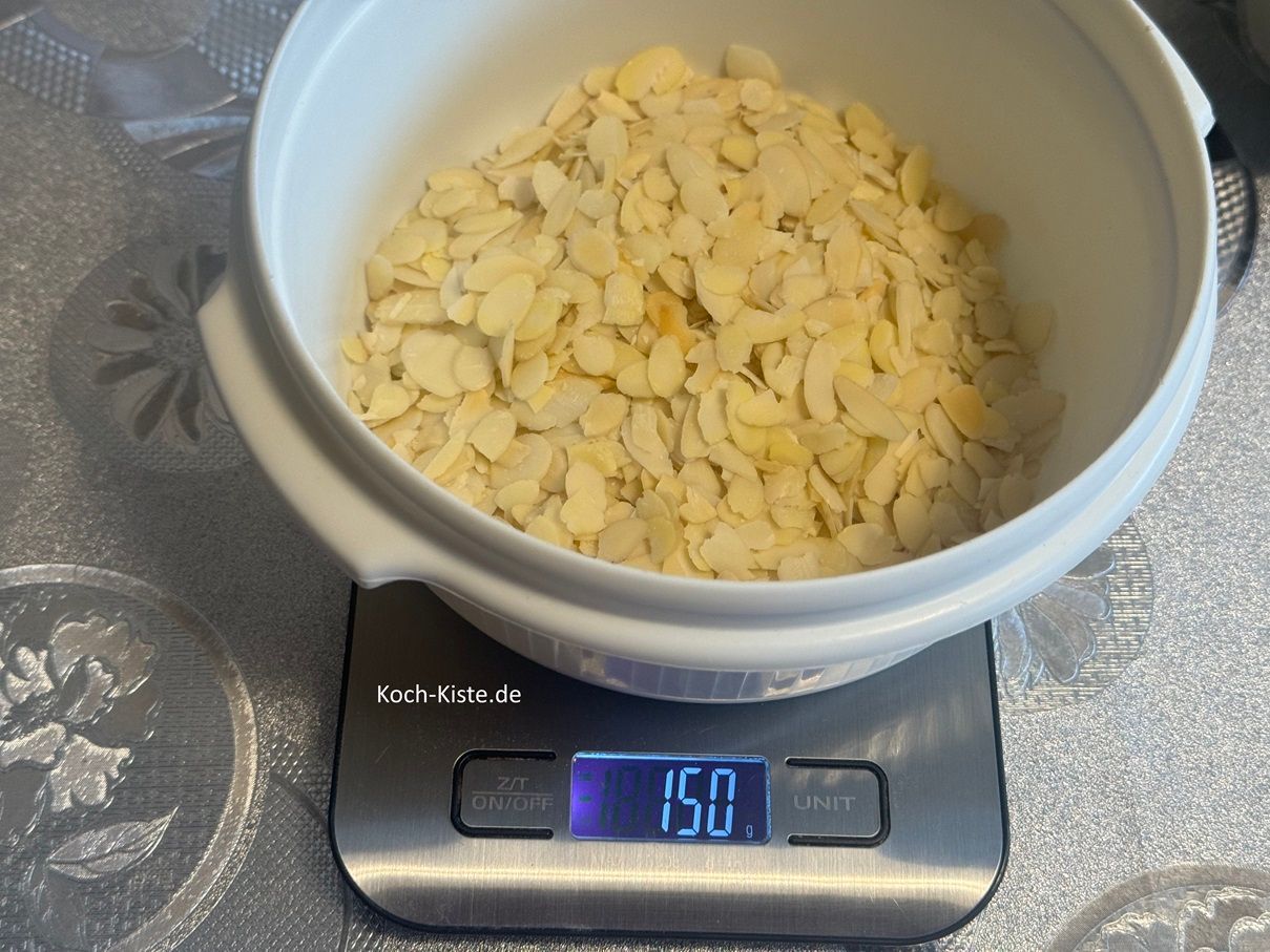 stelle eine extra Schüsssel auf die Küchenwaage auf 0 und wiege 150 g Mandelblättchen hinein