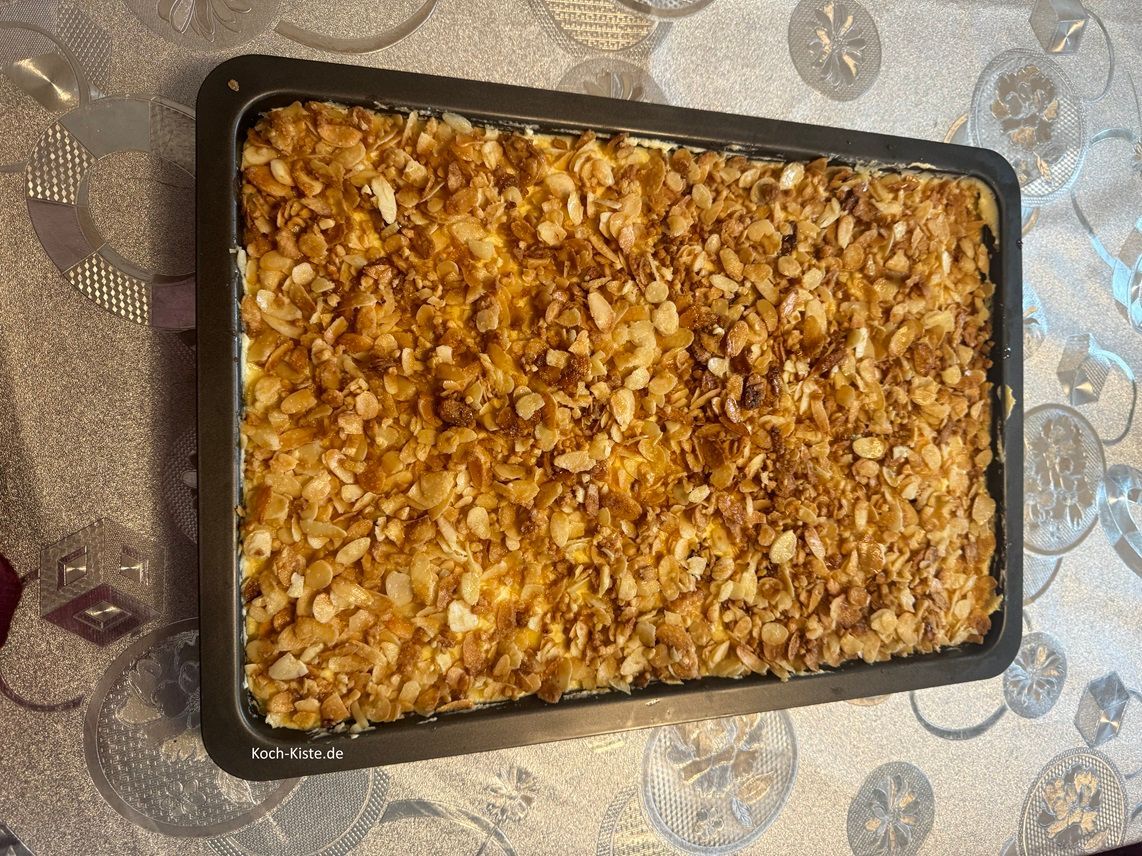 verteile mit einem Esslöffel die Mandel-Zucker Mischung gleichmäßig auf der Puddingschicht - und drücke dabei die Mandeln leicht in den Pudding