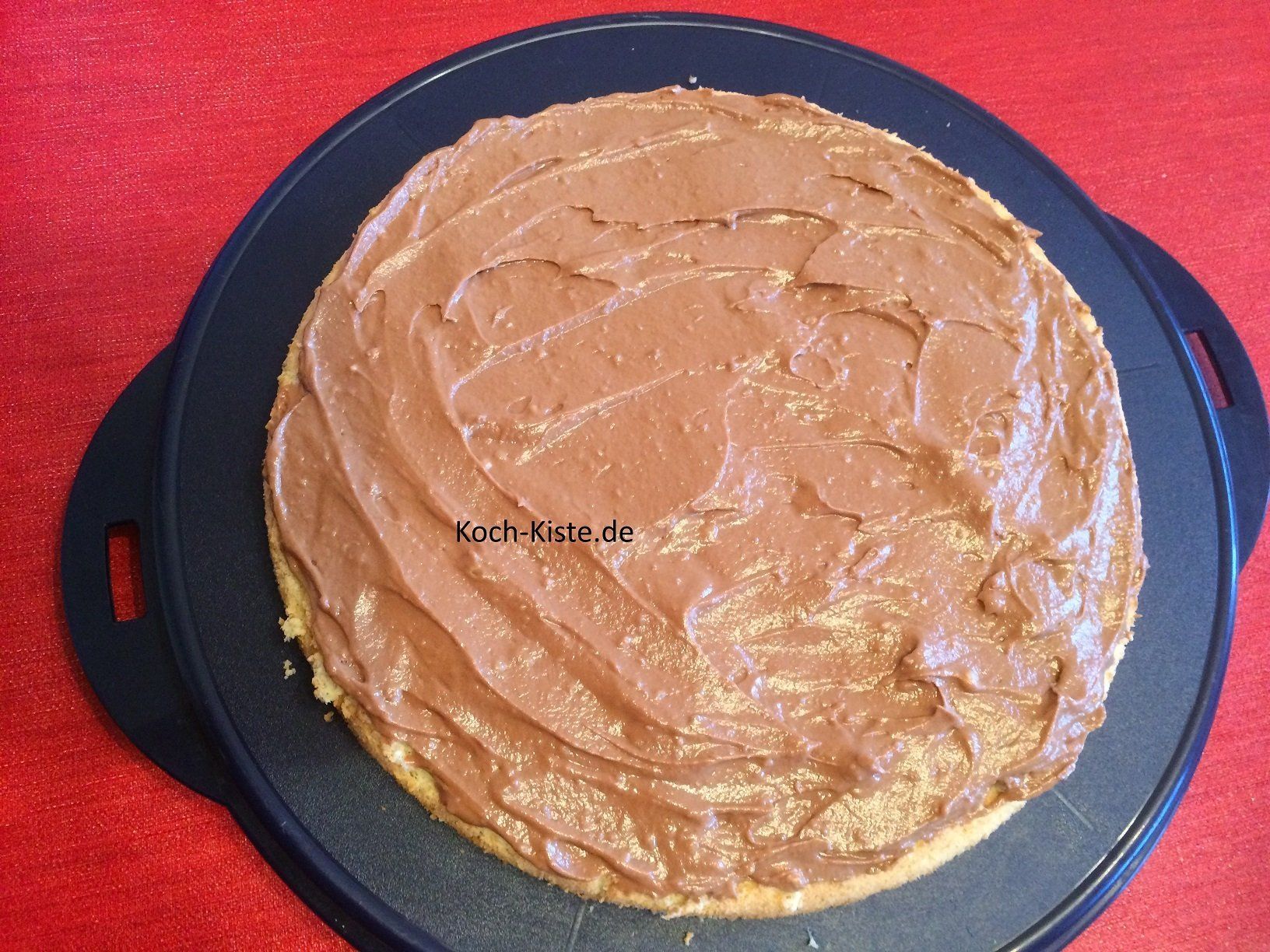 untere Tortenplatte mit Nougat-Buttercreme bestreichen