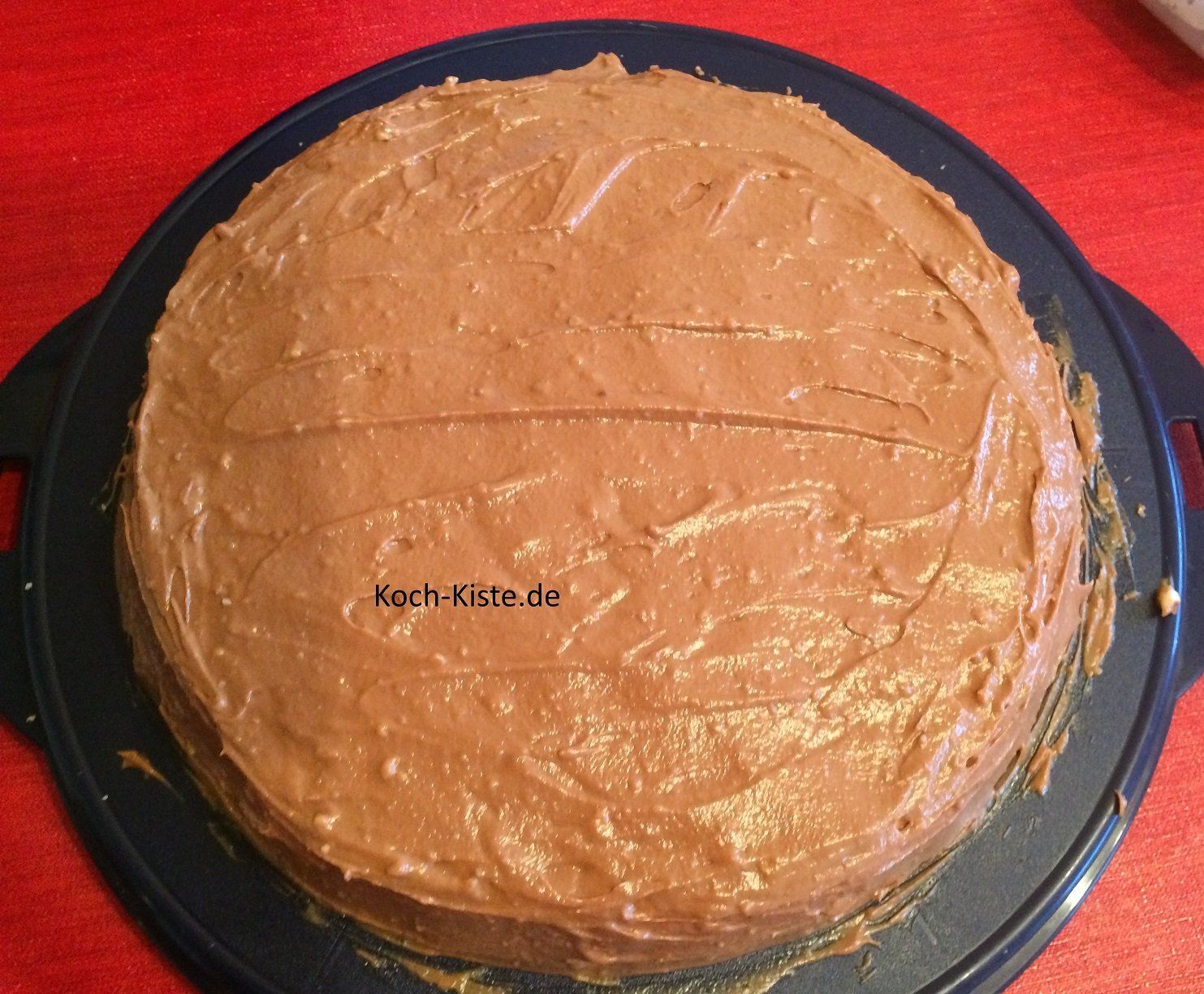 oberer Bisquitboden auflegen und komplett mit Nougat-Buttercreme bestreichen