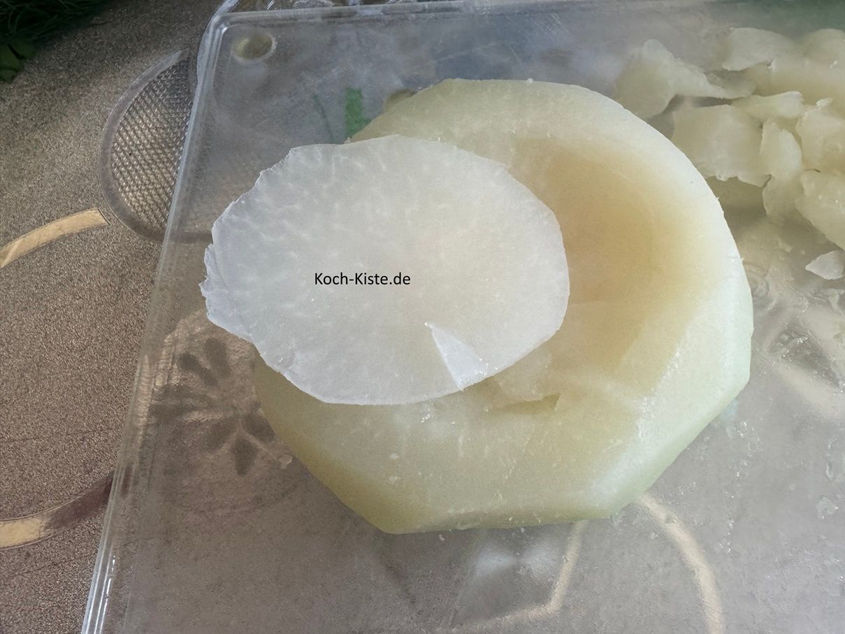 lege einen Kohlrabi auf das Schneidebrett und schneide oben eine dünne Scheibe ab.
