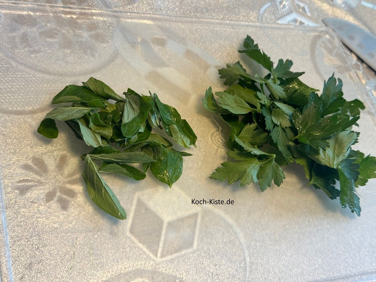 zupfe zuerst vom Oregano die Blätter ab und dann von den Petersiliestielen. Die Stiele kannst Du entsorgen.