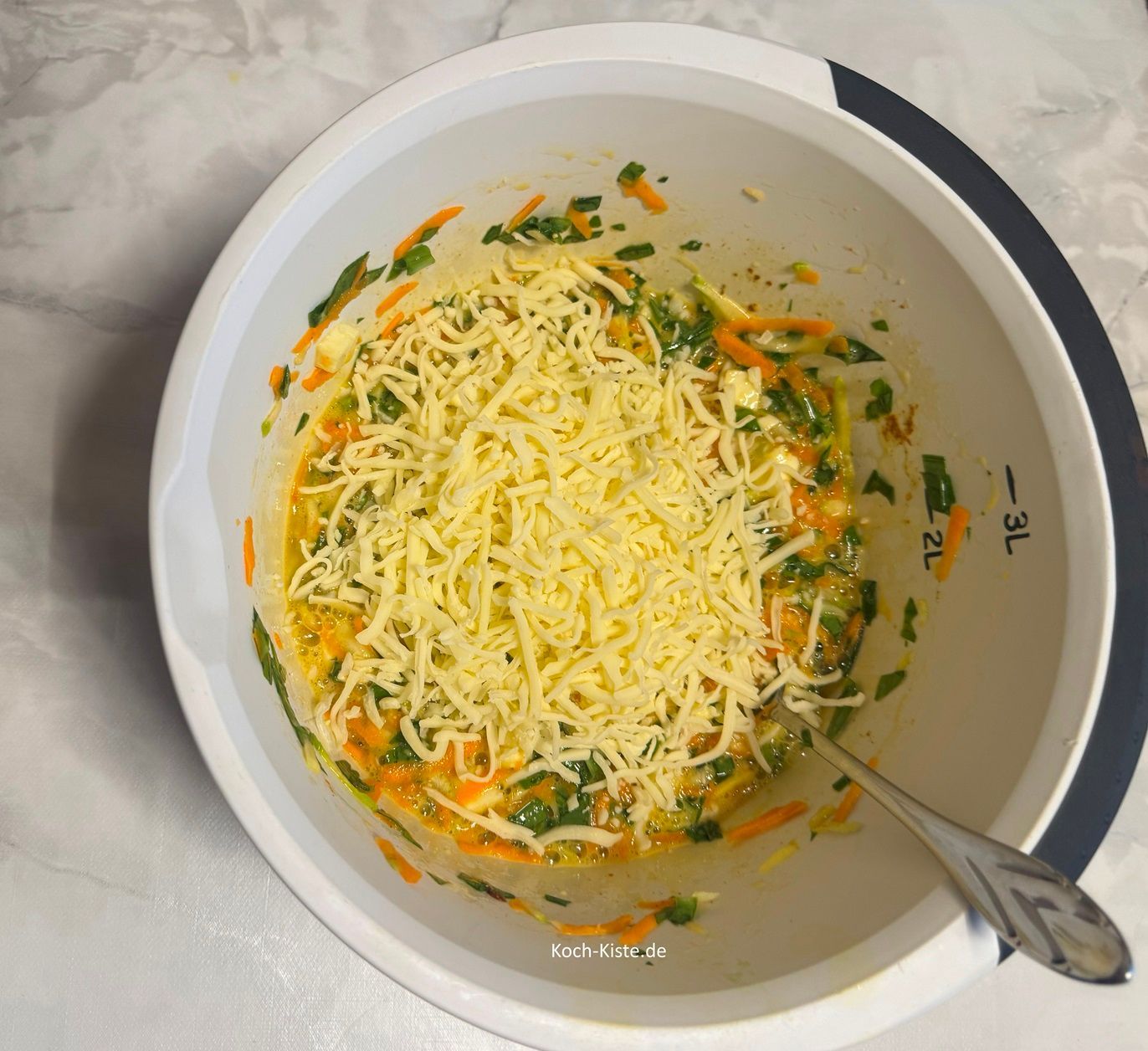 jetzt stelle die Rührschüssel auf die Küchenwaage auf 0 und wiege 100 g geriebenen Käse ab. Verrühre ein letztes Mal alles miteinander.