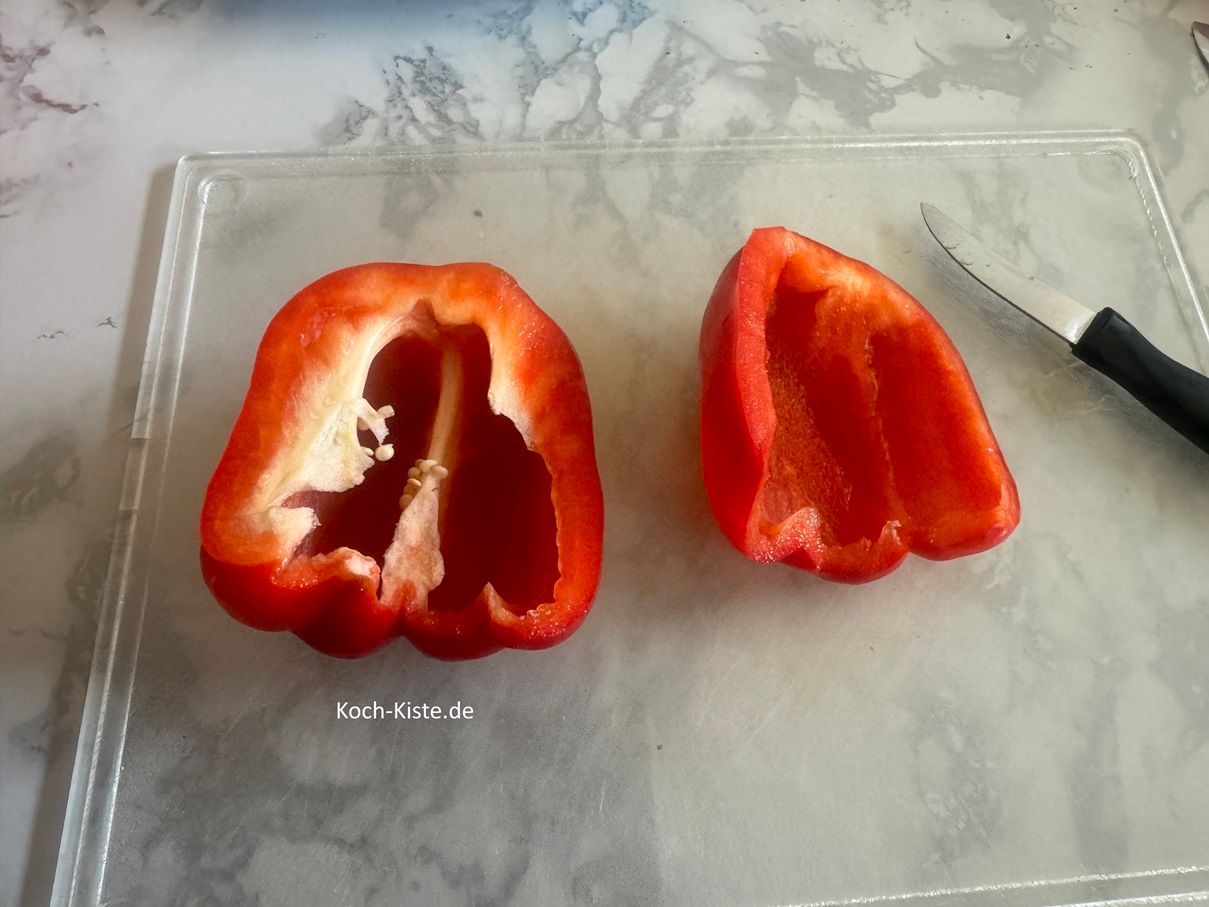 und den Strunk zu entfernen. Danach schneide die Innenhäute heraus und spüle die Paprikahälfte unter fließenden, kaltem Wasser ab. Achte darauf das Du die Kerne weg spülst.