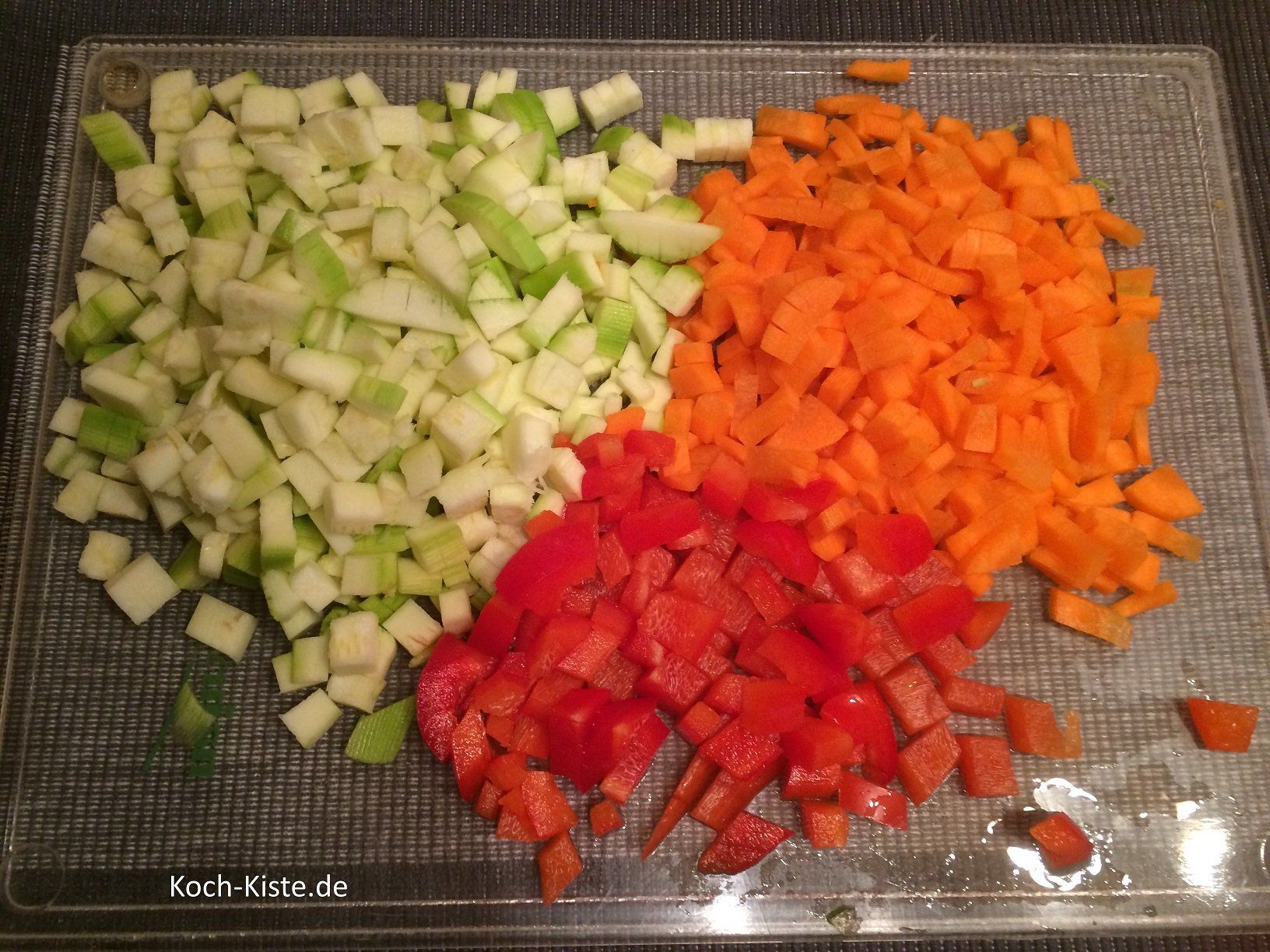 Zucchini, Wurzeln und Paprika in Würfel schneiden