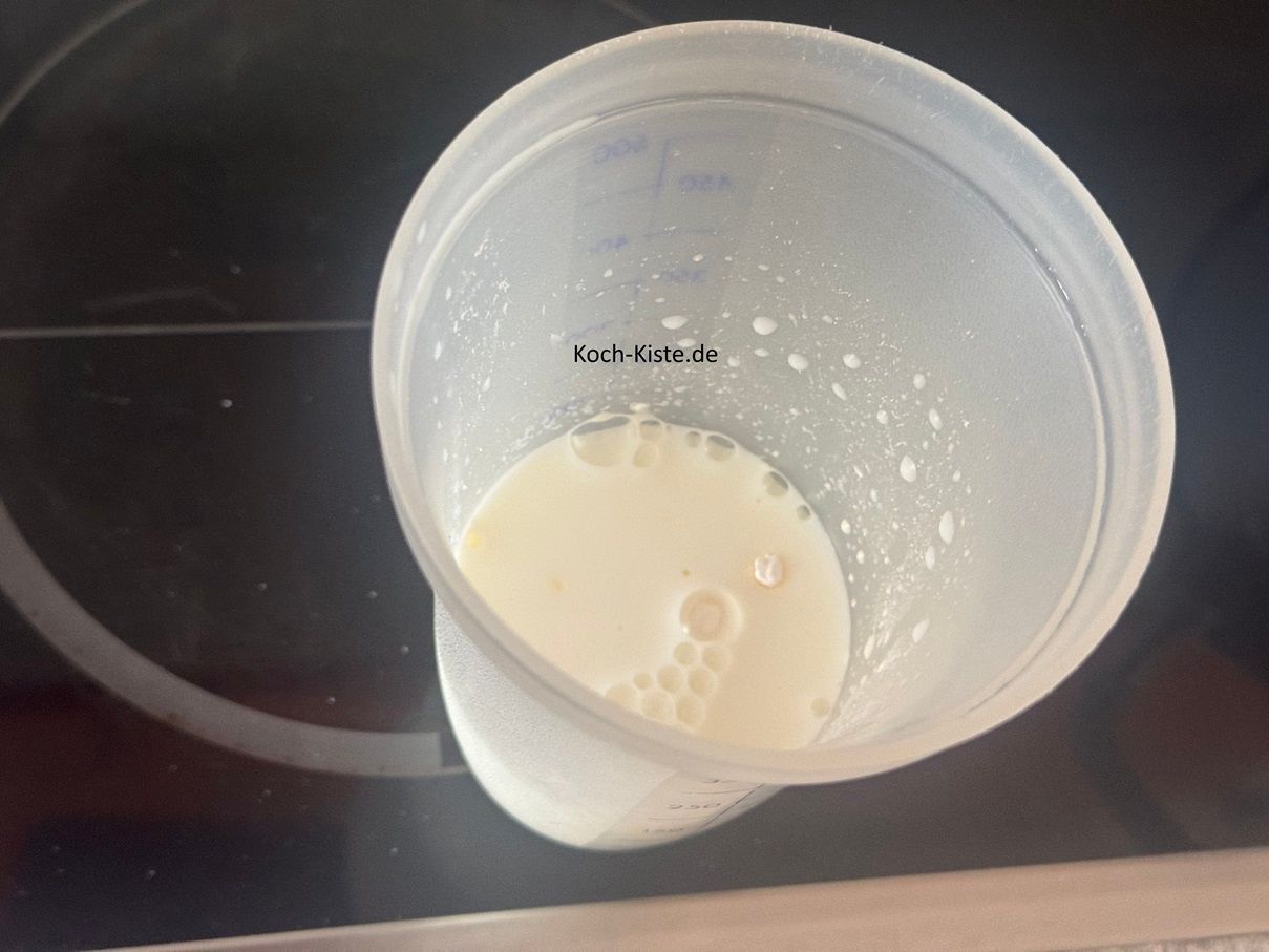 in die Milch im Messbecher kommt 1 Packung Vanillepuddingpulver und 2 Esslöffel Zucker. Verrühre alles mit einem Esslöffel, bis sich Zucker und Puddingpulver aufgelöst haben