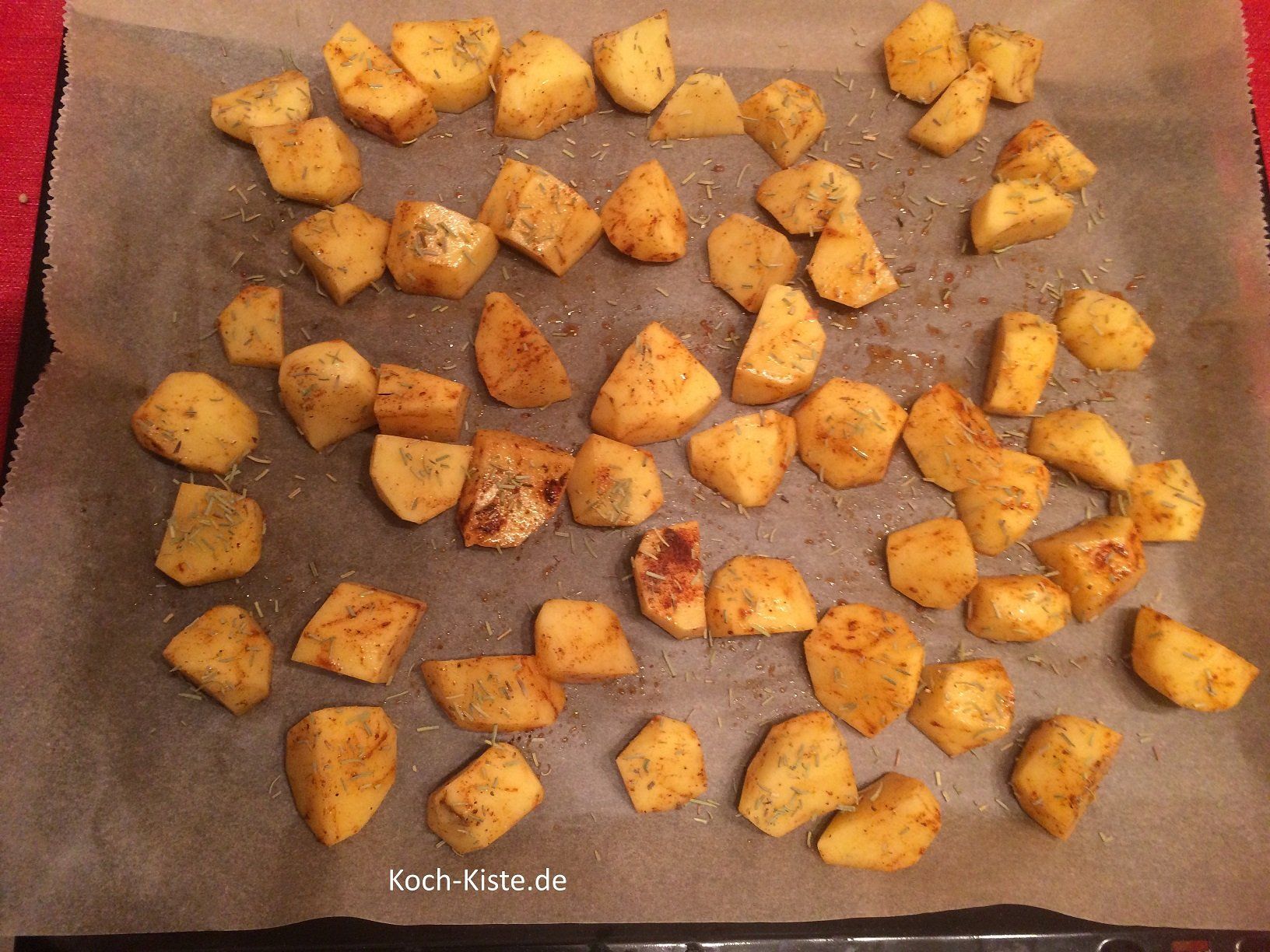 Kartoffelstücke mit Rosmarin würzen und in den Backofen geben
